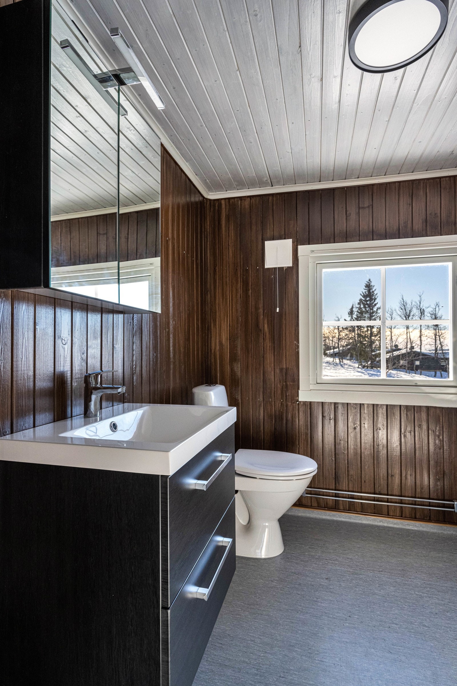 Nytt bad fra 2023. Her er det overflater på gulv av belegg, mens vegger har overflater av trepanel. Galleribilde