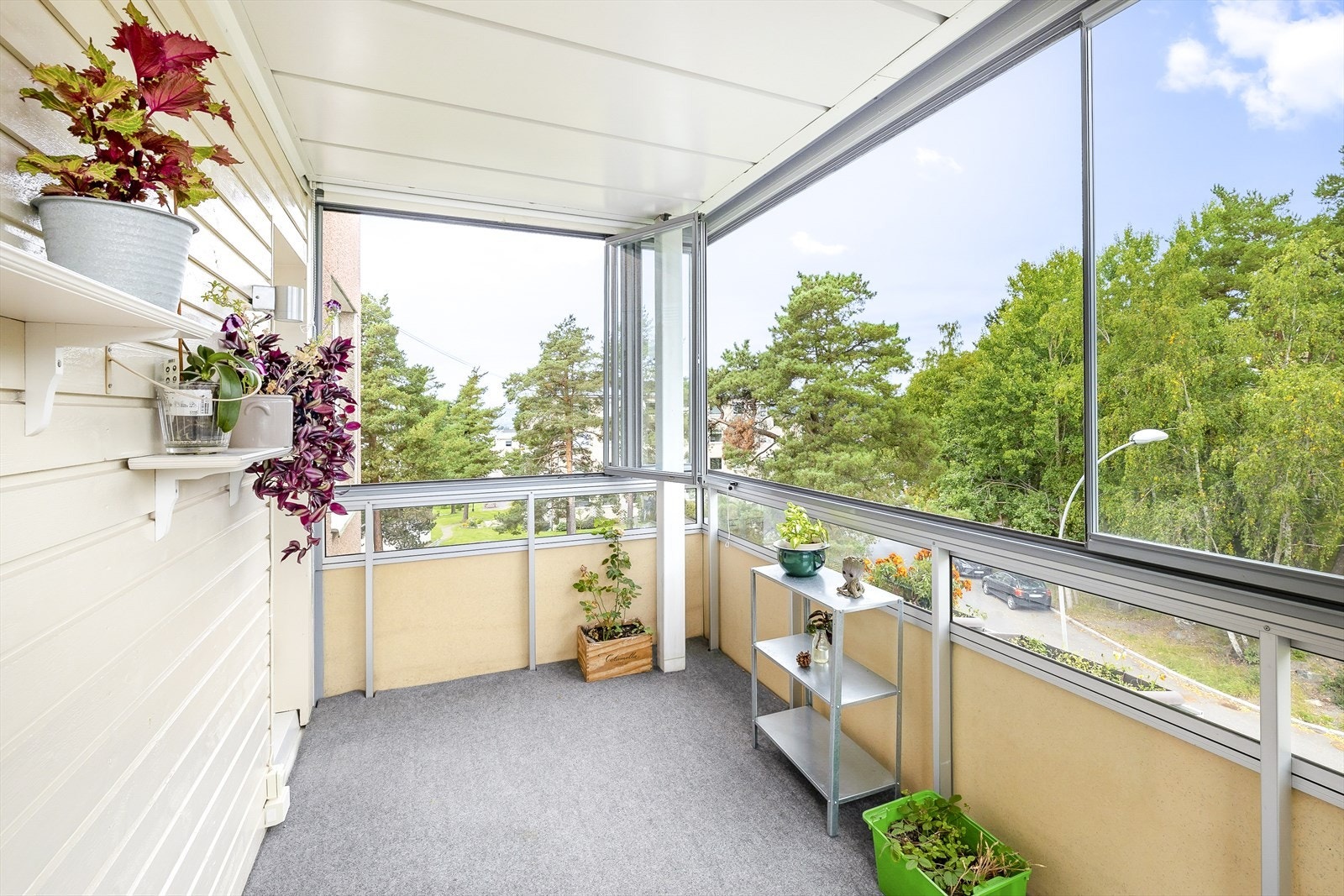 Adkomst fra stue til en nordvendt innglasset balkong med teppe på gulv på ca. 7 m². Galleribilde