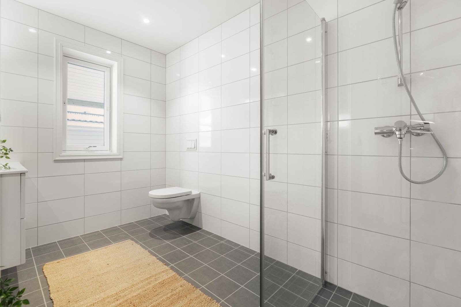 Badet har dusjhjørne med innfellbare glassvegger og down-light belysning i tak. Galleribilde