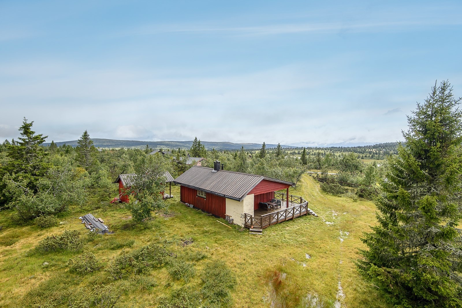 Hytta ligger fint til, skjermet for innsyn og med et hyggelig, åpent og fritt område rundt hytta. Galleribilde