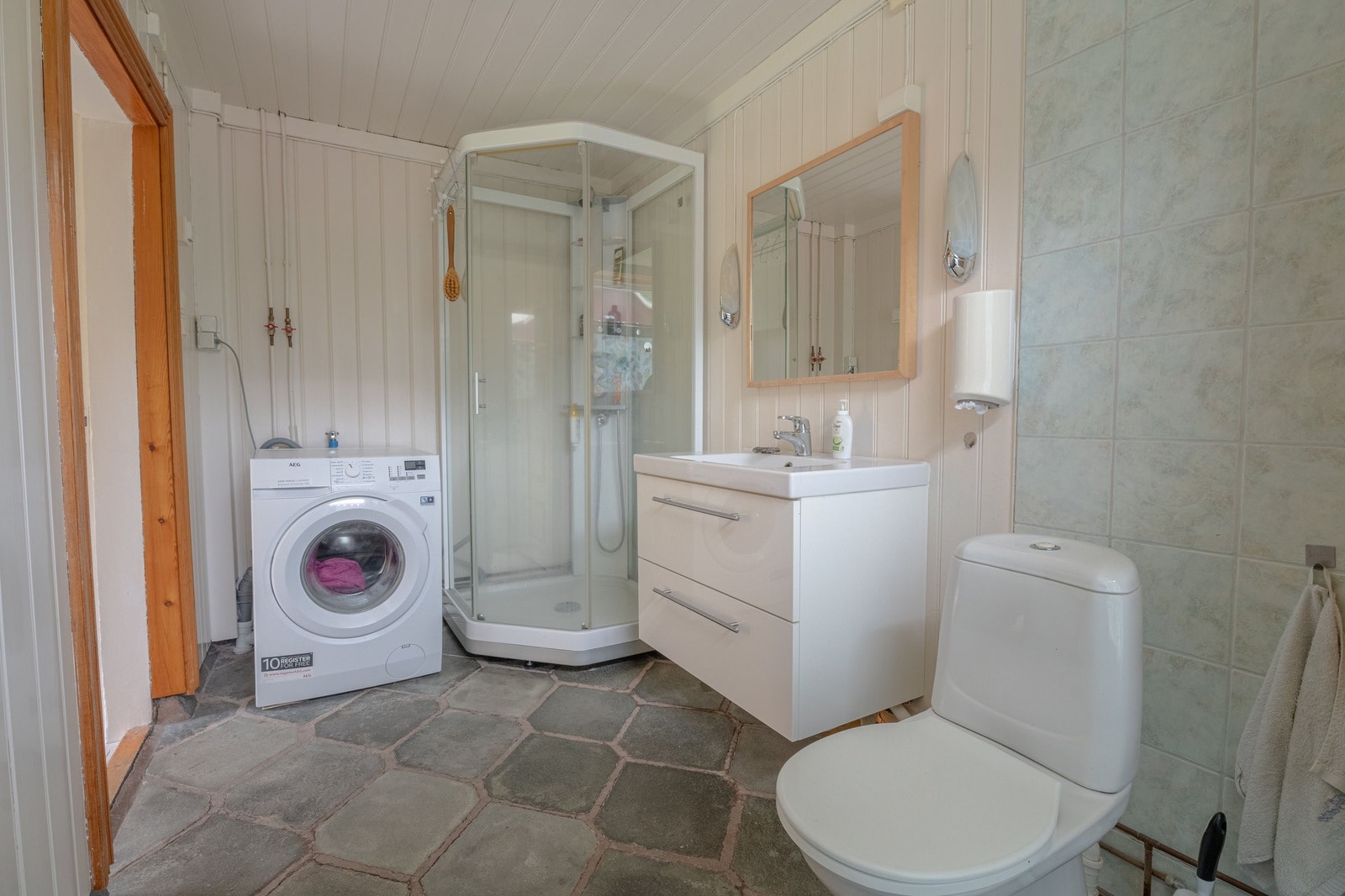Badet har WC, vask, dusjkabinett og opplegg til vaskemaskin Galleribilde