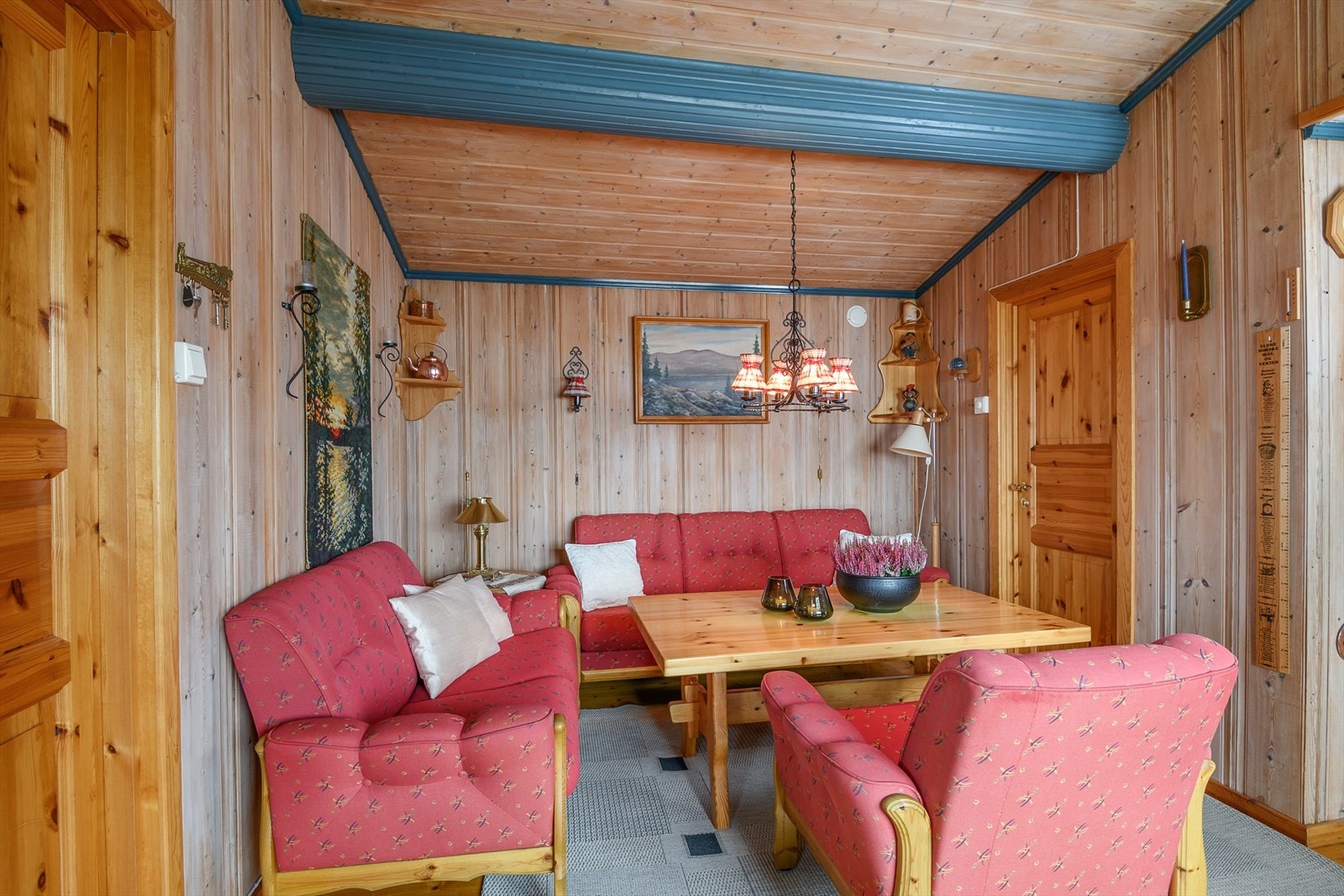 Tradisjonell stil i hytta med panelte vegger og tak og lakkerte tregulv. Galleribilde
