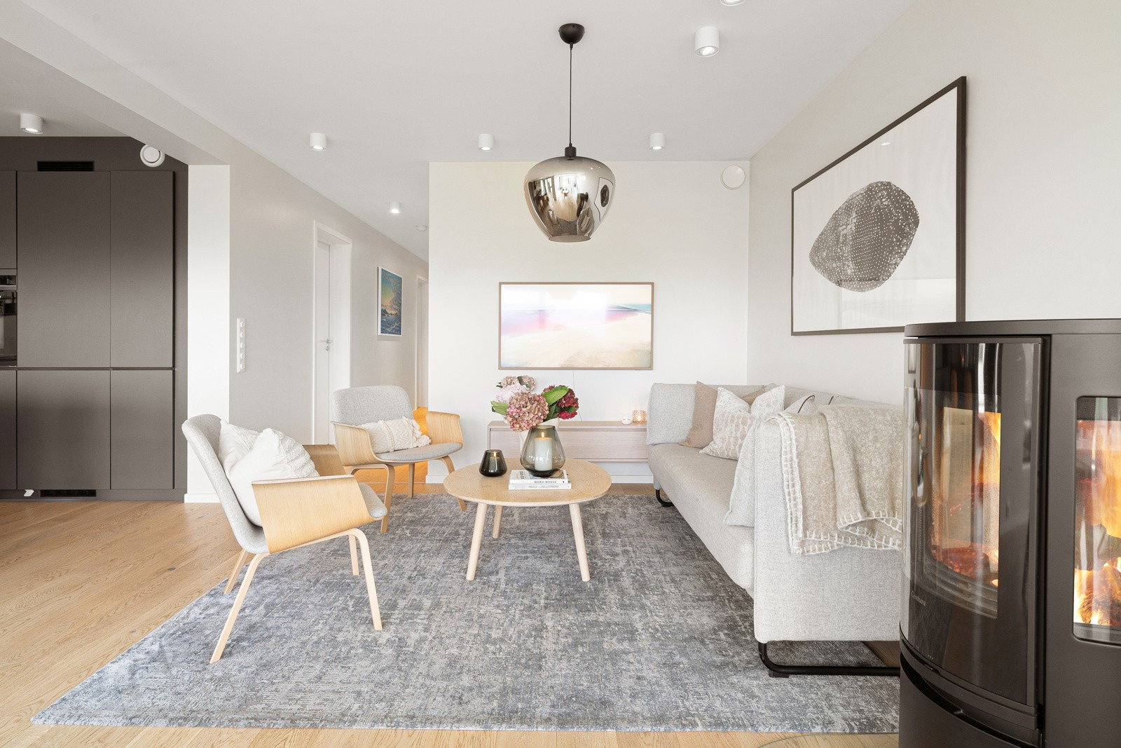 Videre i stuen får sofa en egen krok. Du nyter også en vedovn for varme og hygge på kjøligere kvelder.