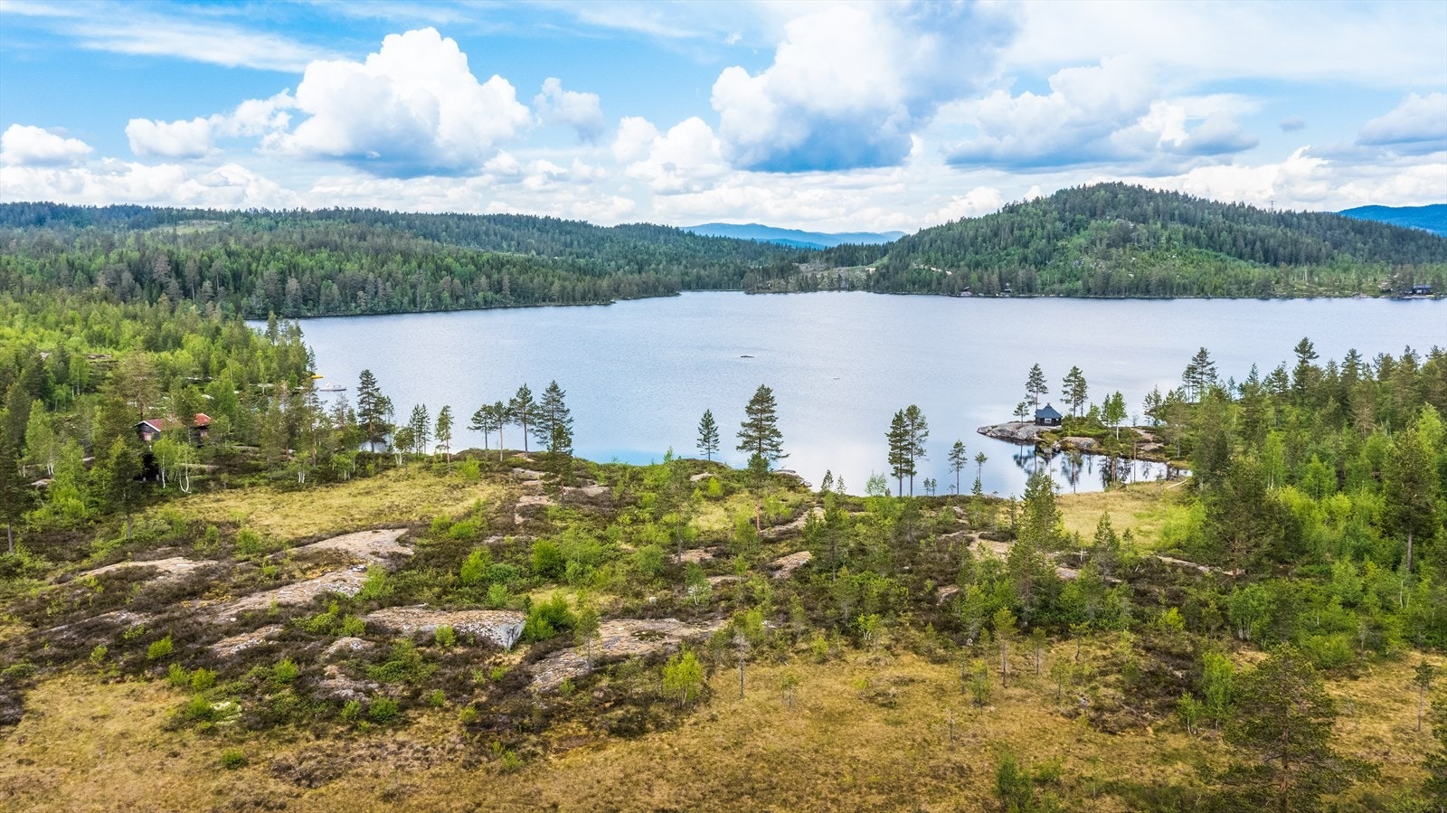 Tomten ligger solrikt til i flatt terreng med utsikt mot fjellene og landskapet rundt, samt vannspeilet i Nystulvannet Galleribilde