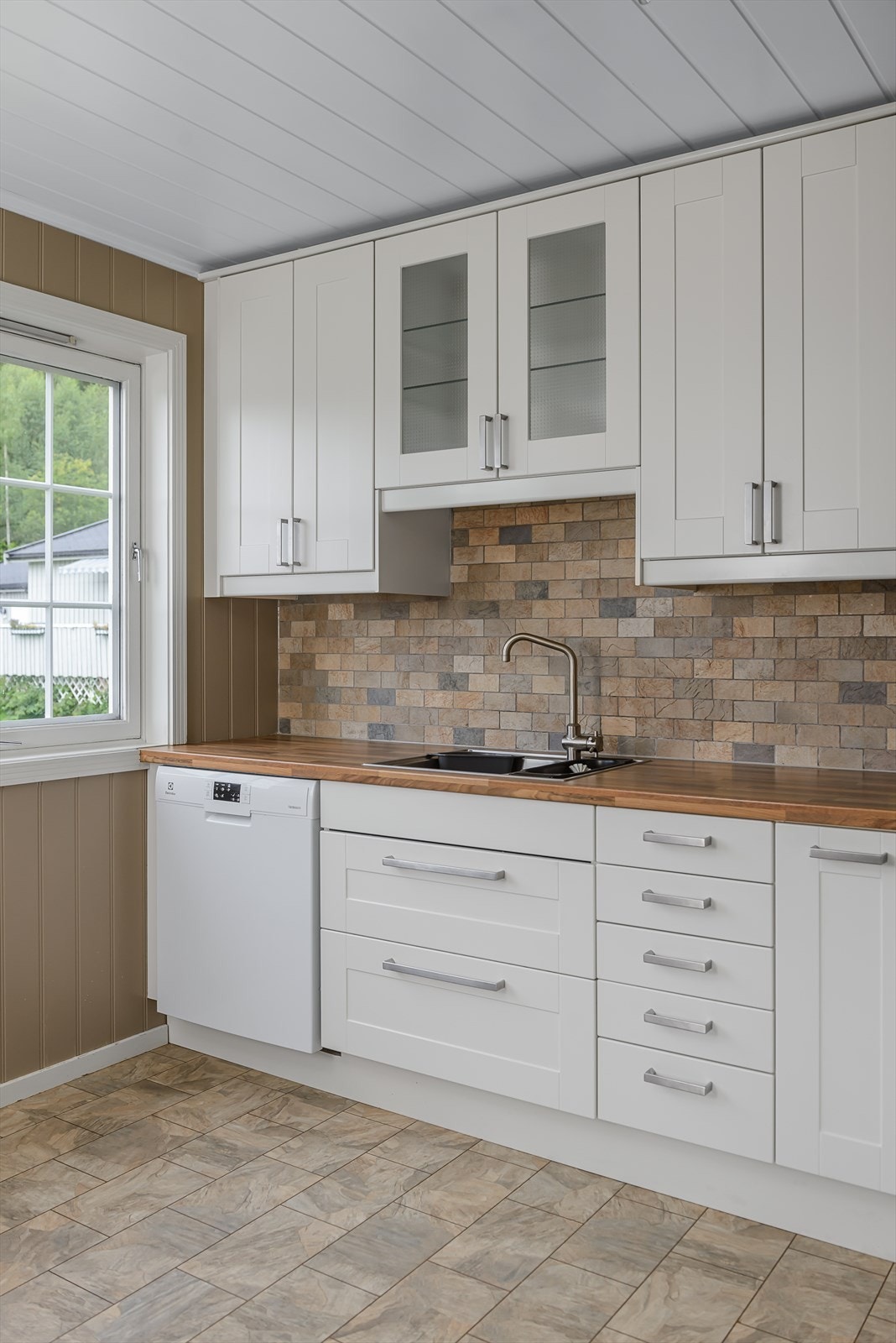 Kjøkkenet har godt med skap og benkeplass Galleribilde