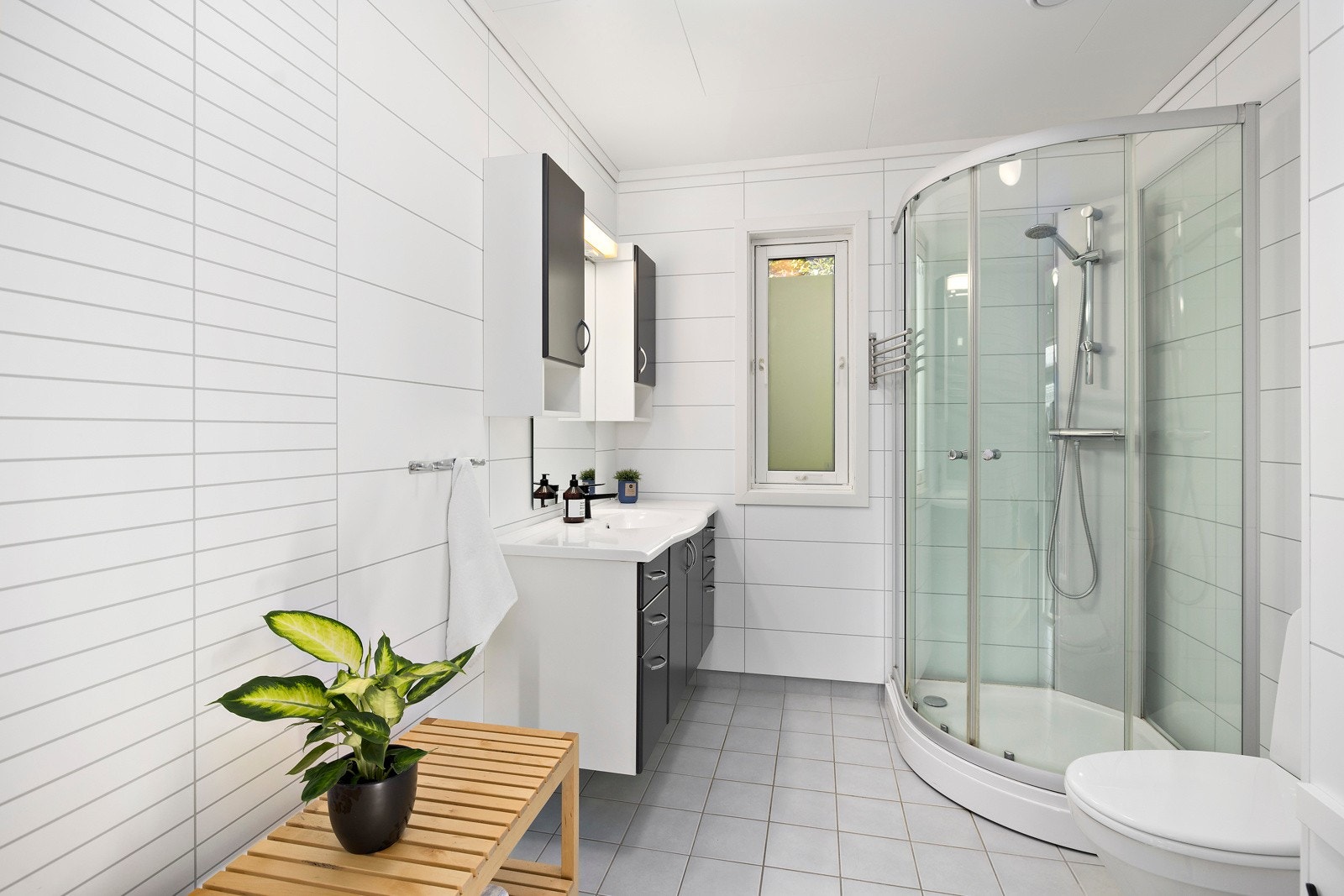 Boligen har to bad med vannbåren gulvvarme. Dette badet ligger i 2. etasje, med toalett, innredning og dusjkabinett. Galleribilde