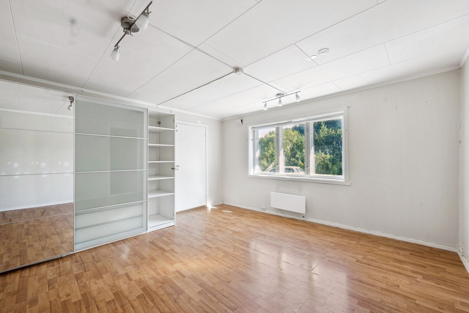 Romslig soverom med skyvedørsgarderobe, sprekk i speildør. Galleribilde
