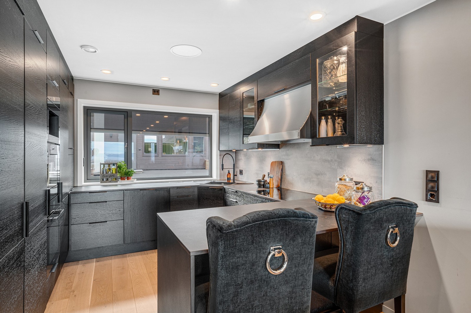 Stilfullt, påkostet kjøkken fra Aubo med dekton benkeplate. Kjøkkenvindu har motorisert solskjerming/screens fra Fasadeprodukter. Galleribilde