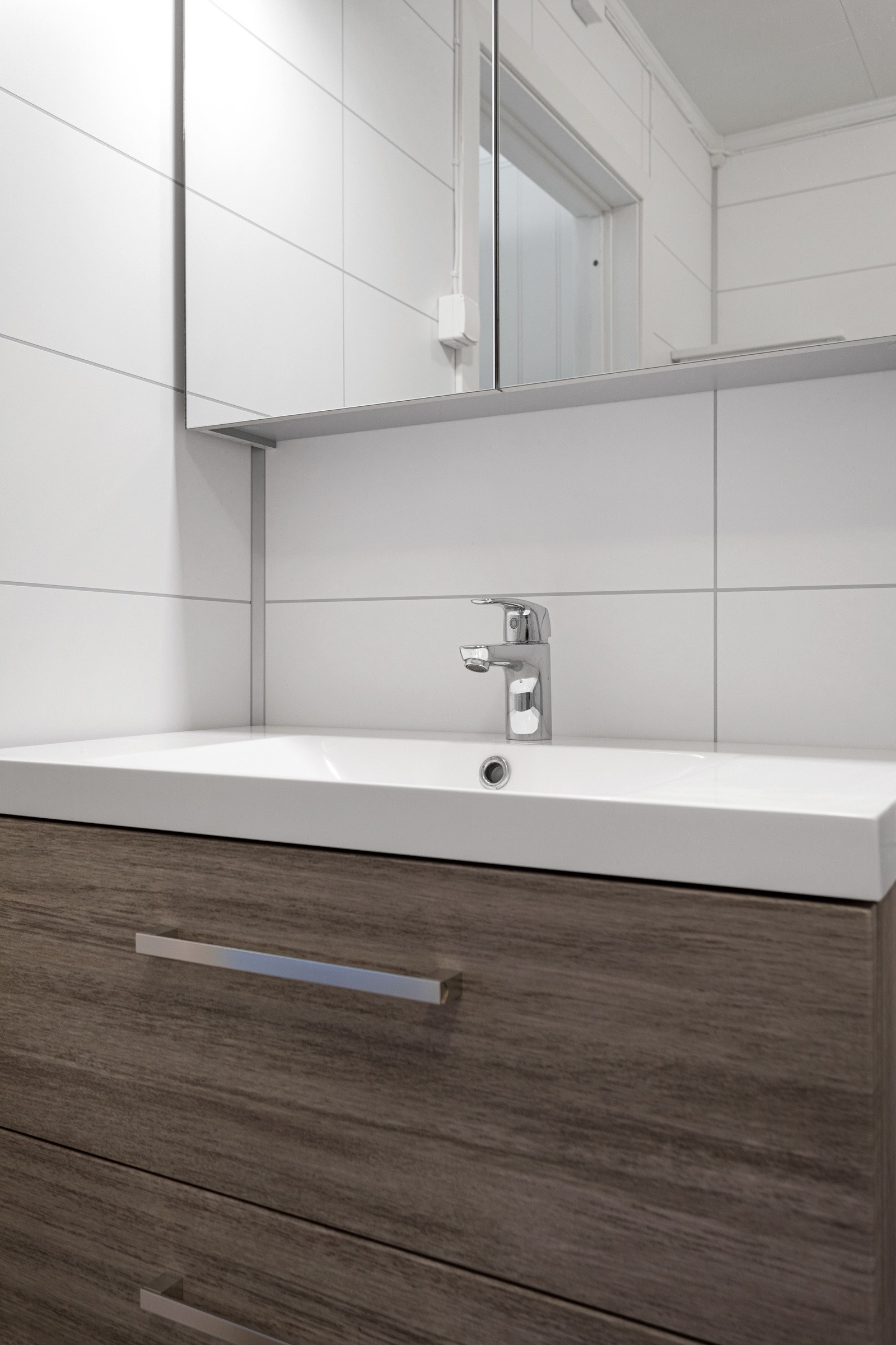 Badet er innredet med servant på innredning, toalett og dusjhjørne. Galleribilde