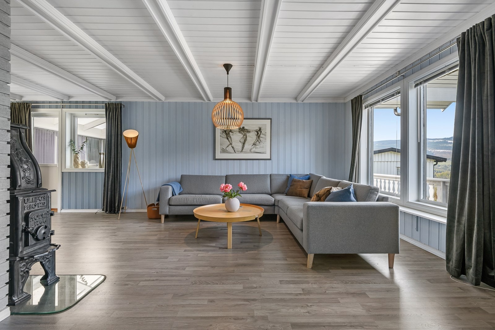 Stuen er lekkert innredet med hvitmalt himling med åser, og vegger malt i en dus blå farge. Galleribilde