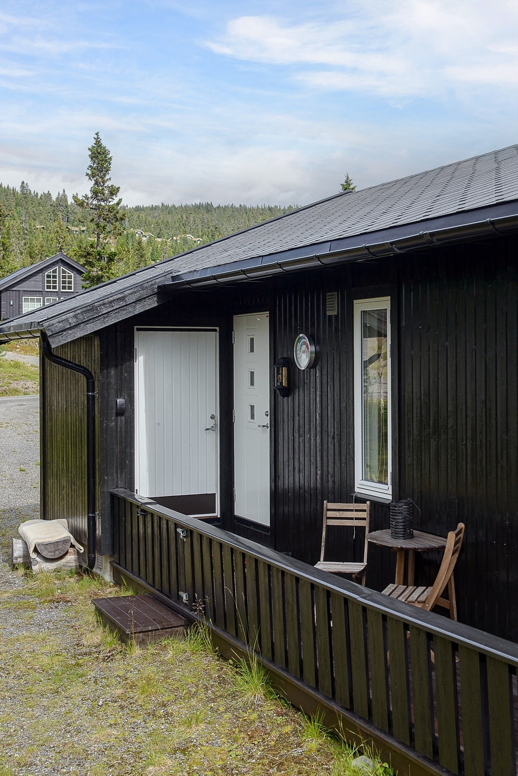 Bod for oppbevaring av sportsutstyr ved inngangen. Terrassen går på 2 sider av hytta. Galleribilde