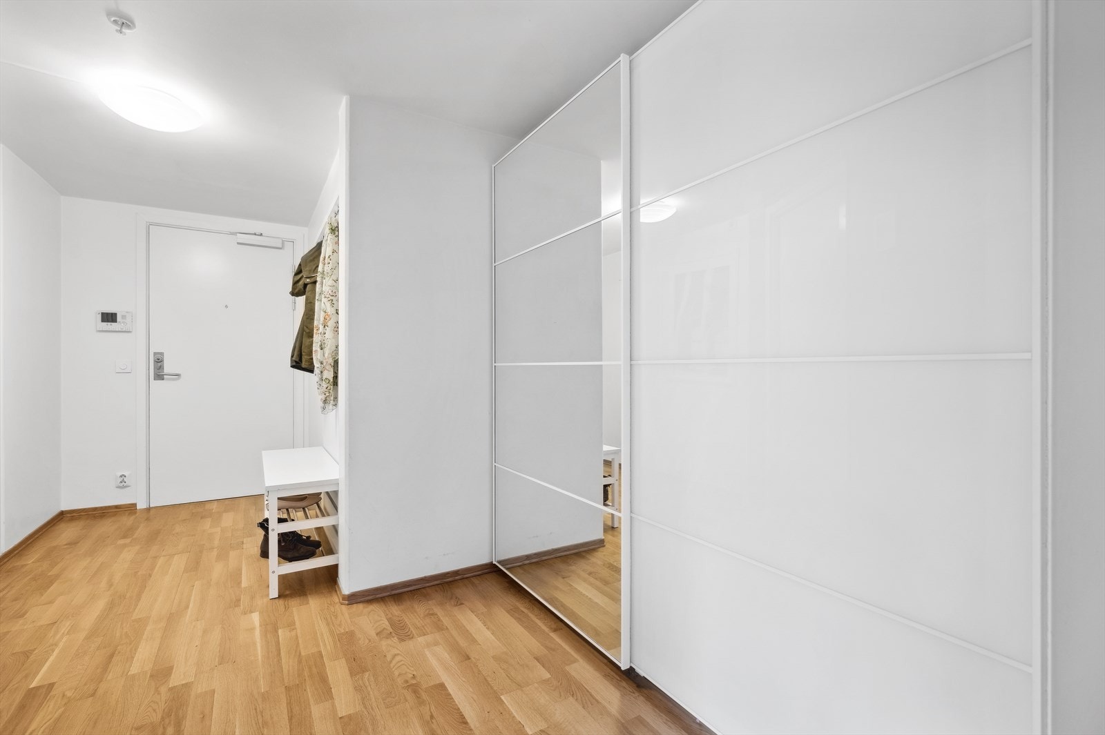 Romslig entrè med skyvedørdsgarderobe. Praktisk innredning til sko og yttertøy. Galleribilde