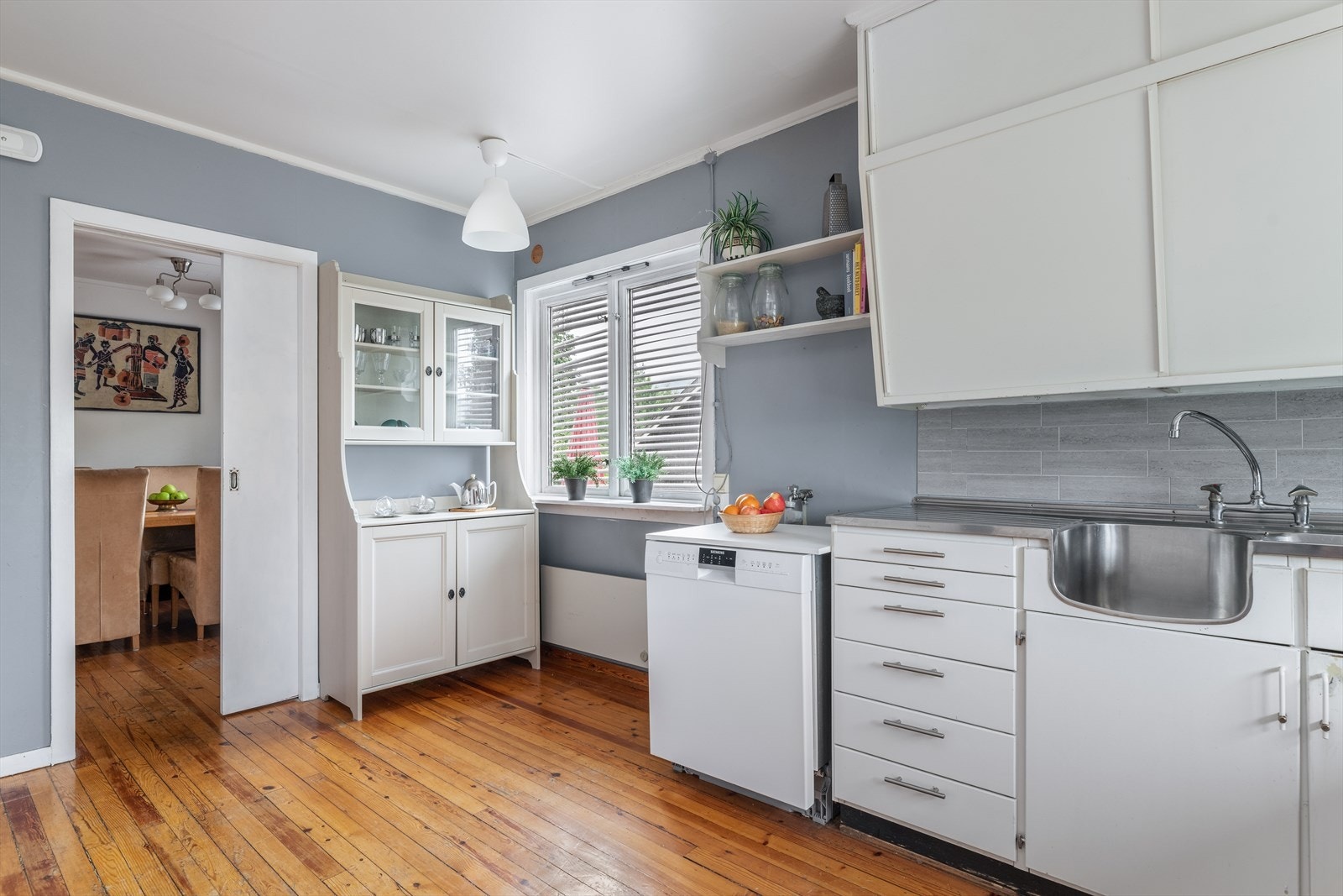 Laminat benkeplate langs med vinduet, og helbeslått vask med skyllekum. Galleribilde