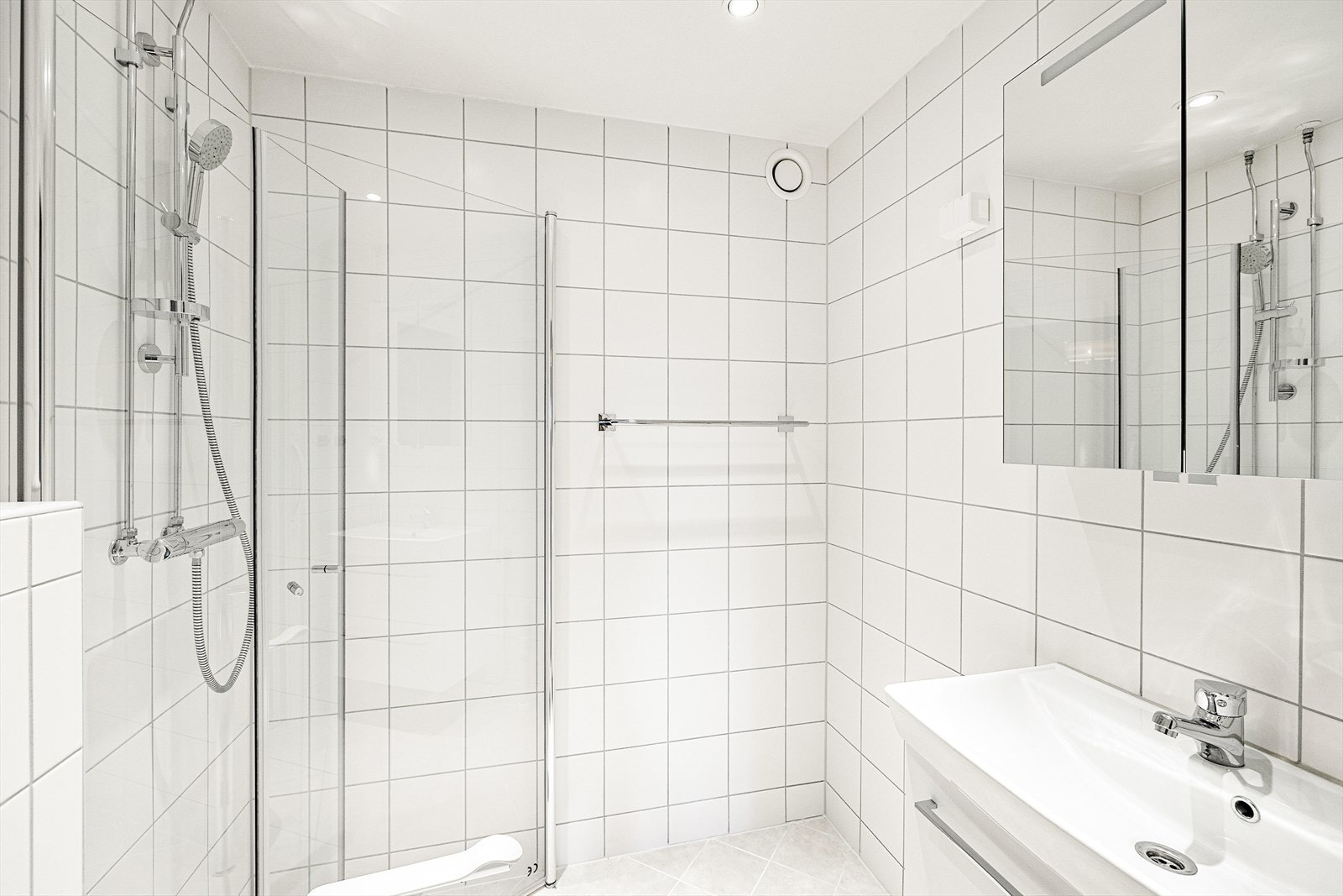 Flislagt baderom ,med gulvvarme og downlights. Innredningen består av inn- utadslående dusjvegger, servant m/underskap, overskap m/speilfronter, veggklosett og opplegg for vaskemaskin. Rehabilitert i 2014 i regi av sameiet. Galleribilde