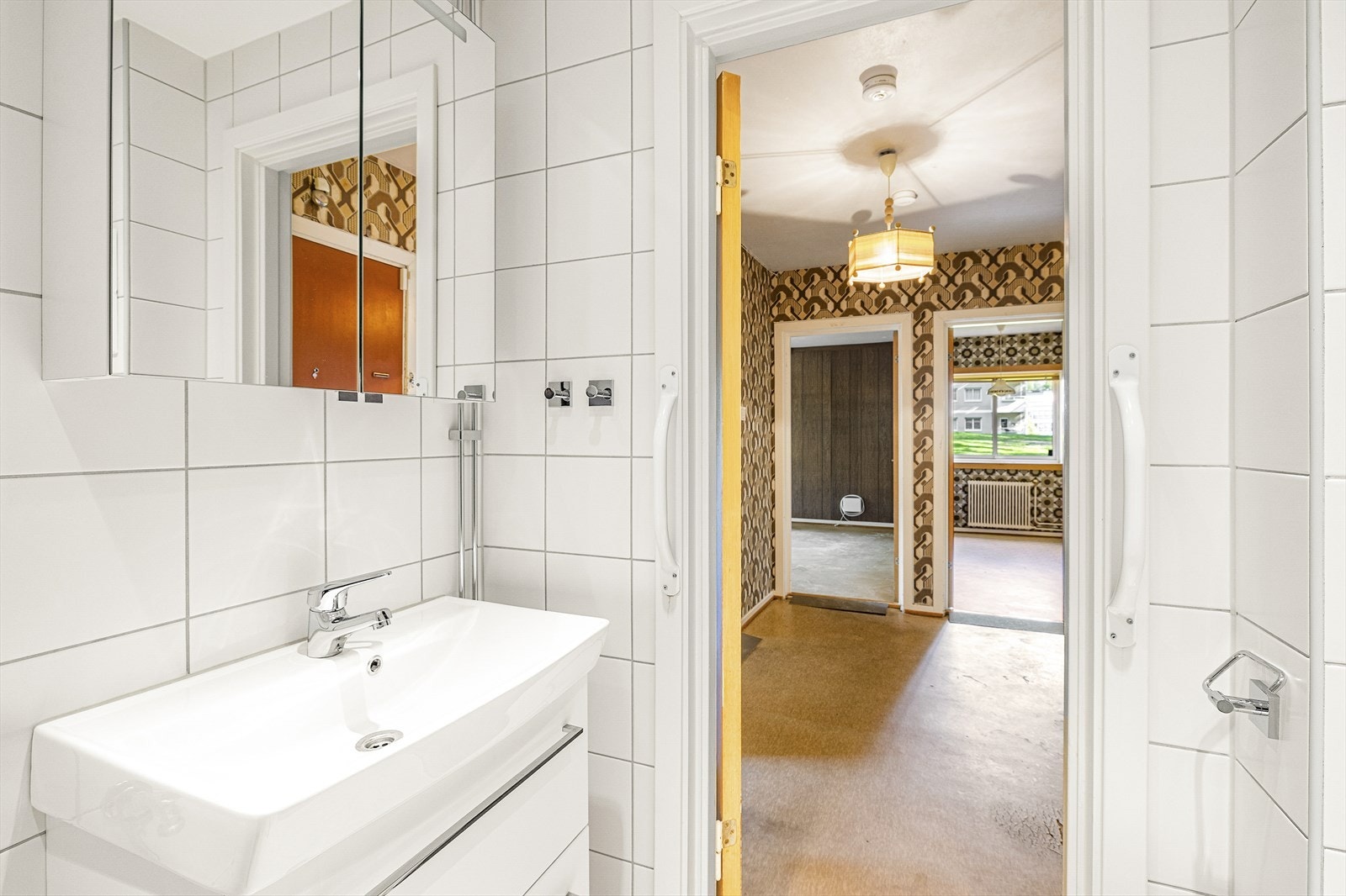 Flislagt baderom ,med gulvvarme og downlights. Innredningen består av inn- utadslående dusjvegger, servant m/underskap, overskap m/speilfronter, veggklosett og opplegg for vaskemaskin. Rehabilitert i 2014 i regi av sameiet. Galleribilde