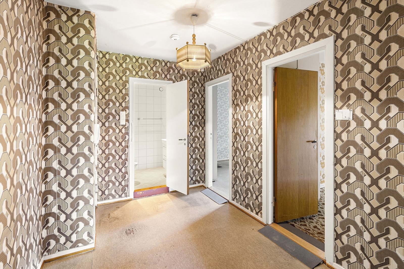 Entré med belegg på gulv, tapet på vegger og malt tak. Det er montert dørcallinganlegg. God plass for yttertøy og sko. Galleribilde