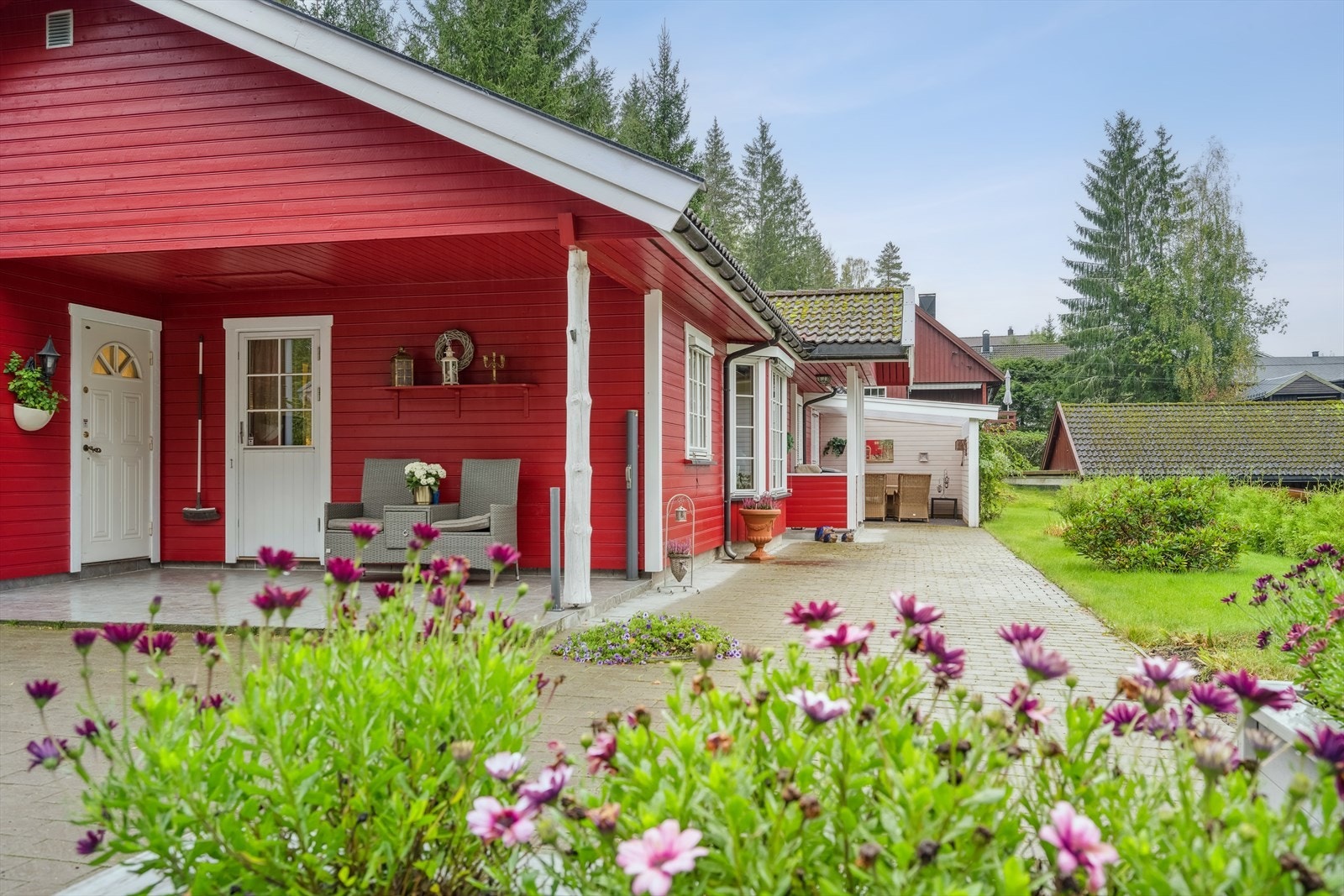 Tomten er relativt flat og pent opparbeidet med gruslagt gårdsplass, gangvei av belegningsstein, plen, hekk og diverse beplantning Galleribilde