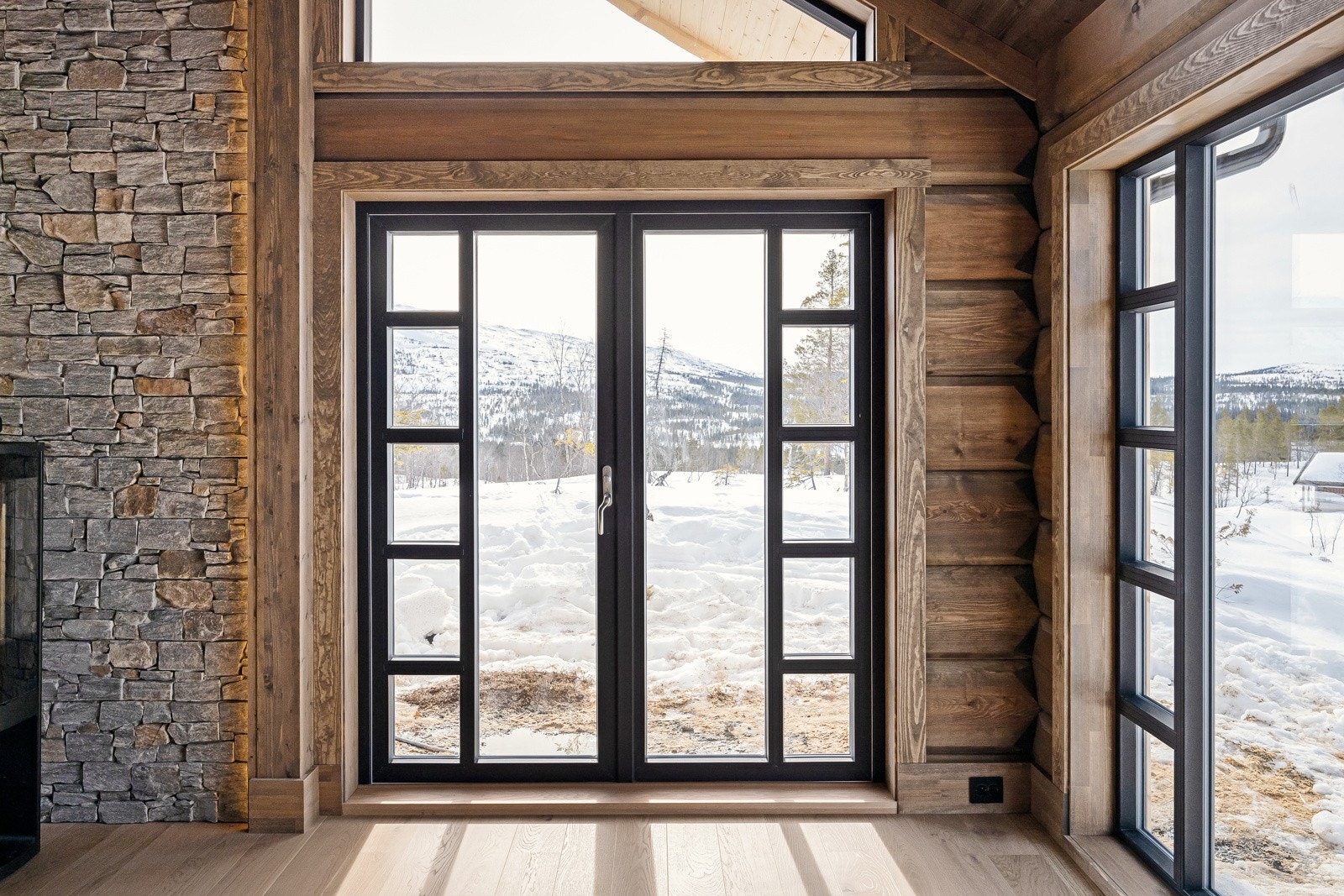Sorte detaljer rundt vinduer og dører gir et moderne og fint uttrykk av hytta. Galleribilde