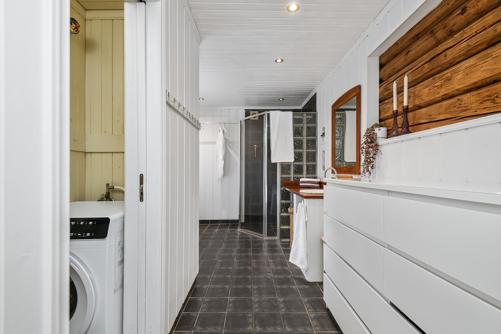 Badet er av god størrelse med opplegg for vaskemaskin i nisje med skyvedør Galleribilde
