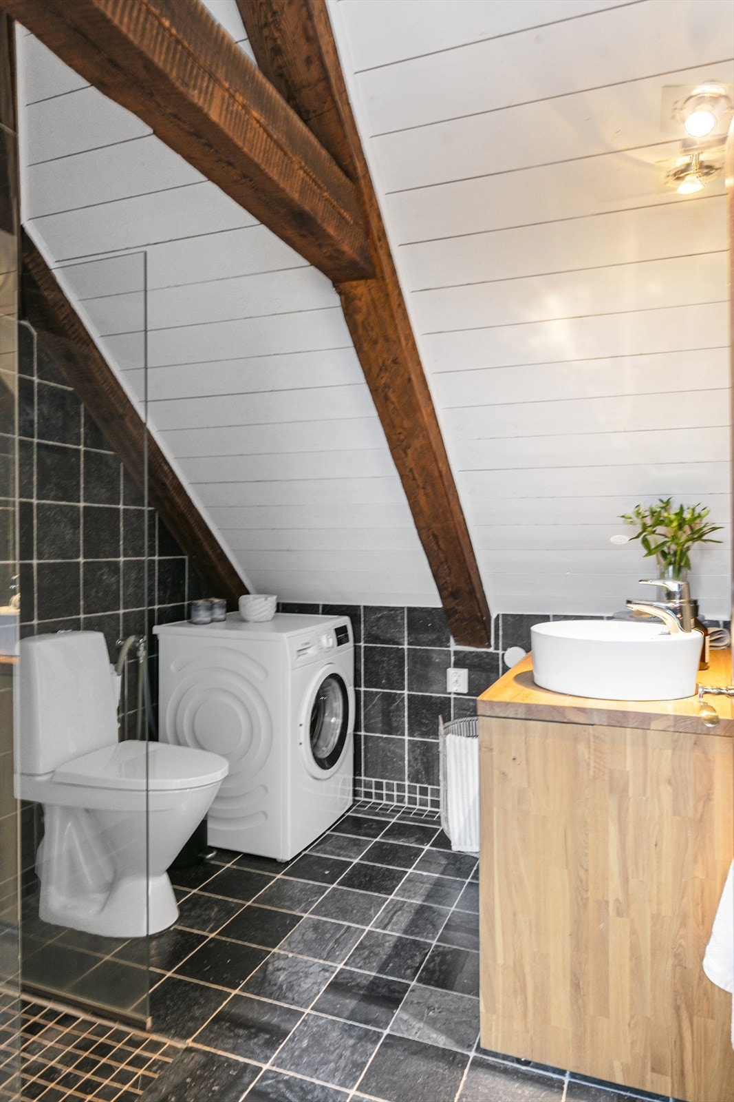 I denne etasjen er det også et pent bad med fliser, varmekabler, servant med baderomsinnredning, toalett og plass til vaskemaskin. Galleribilde
