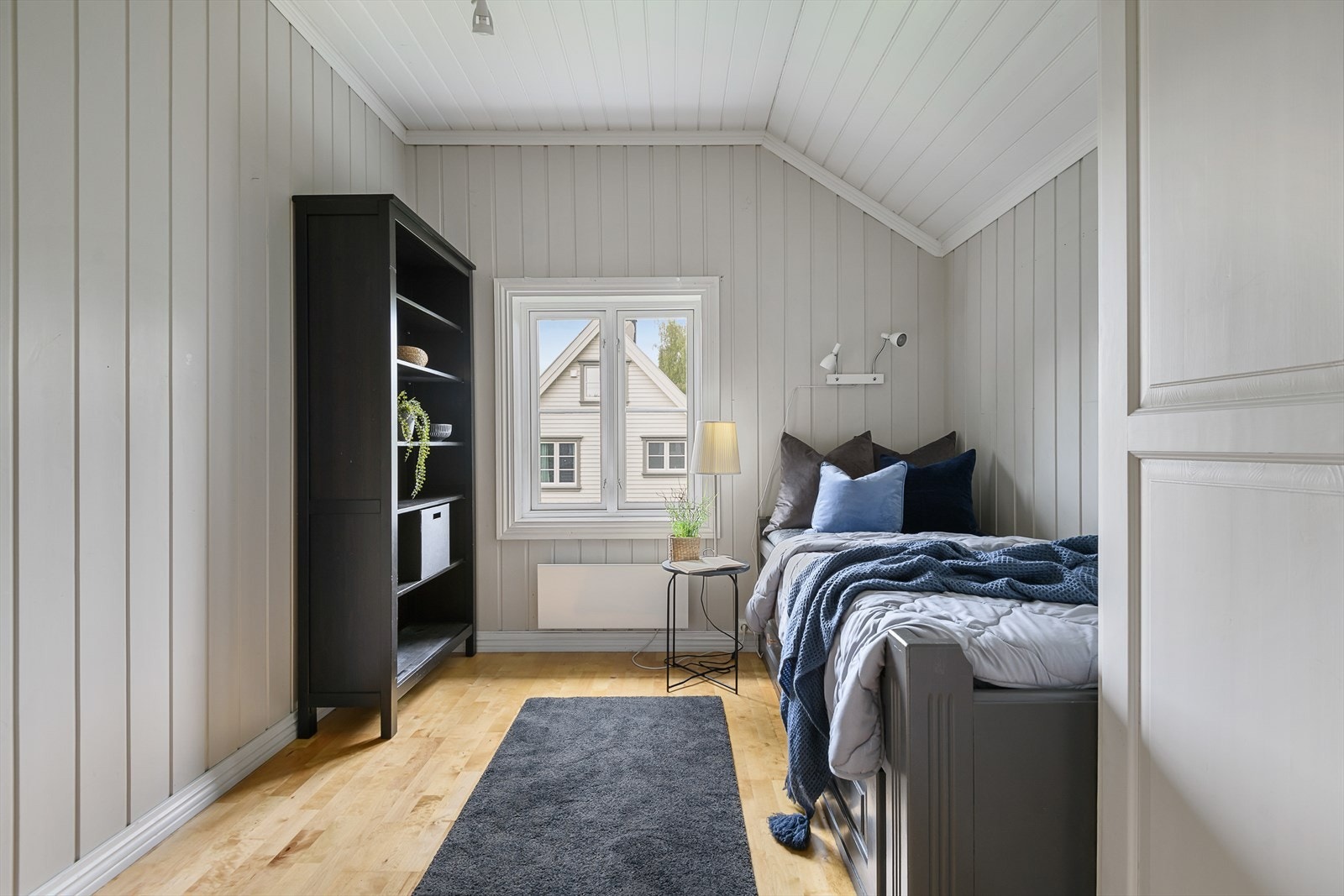 Det 3. soverommet i 2. etasje er malt i en tidløs gråtone. Innredet med enkeltseng. Plass til oppbevaringsmøbel. Galleribilde