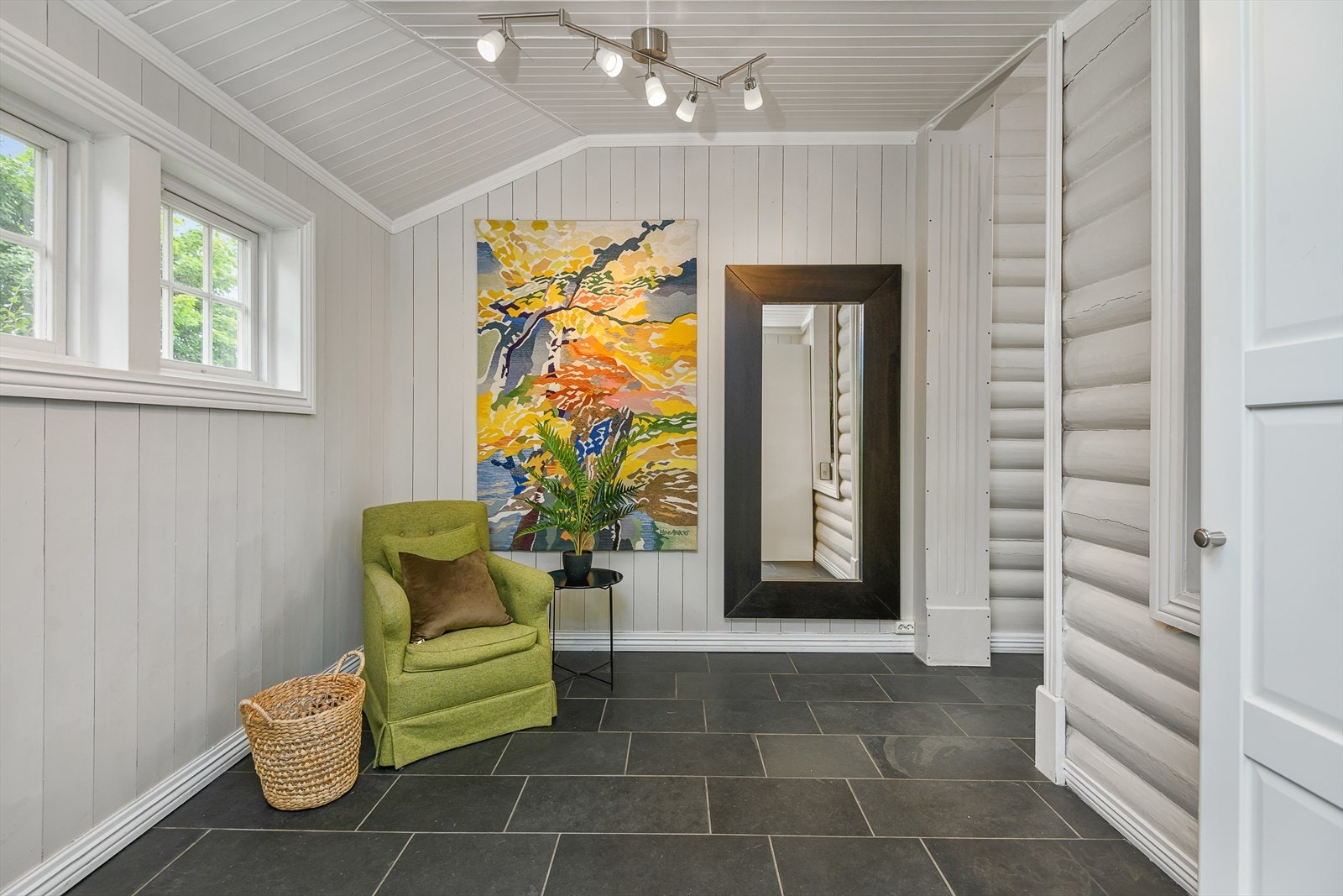 Hyggelig gang med en kombinasjon av tømmervegger og malt panel. Fliser på gulvet. Galleribilde