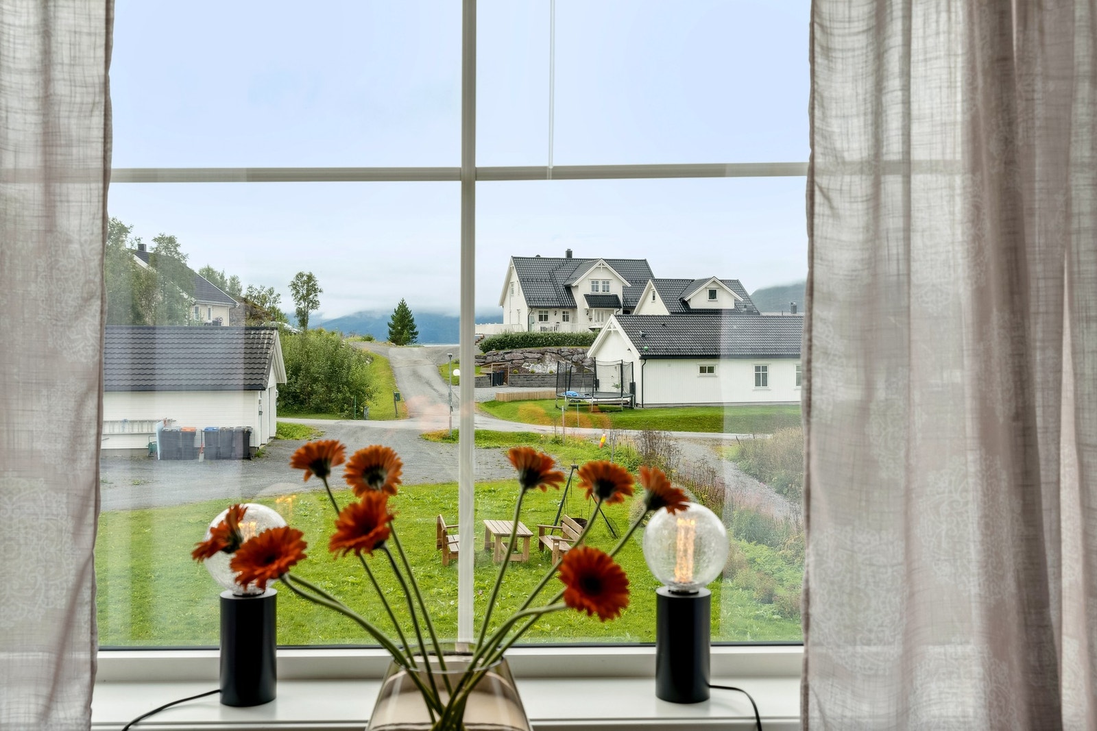 Fin, grønn utsikt fra stua. Fellesområdet er pent opparbeidet. Galleribilde
