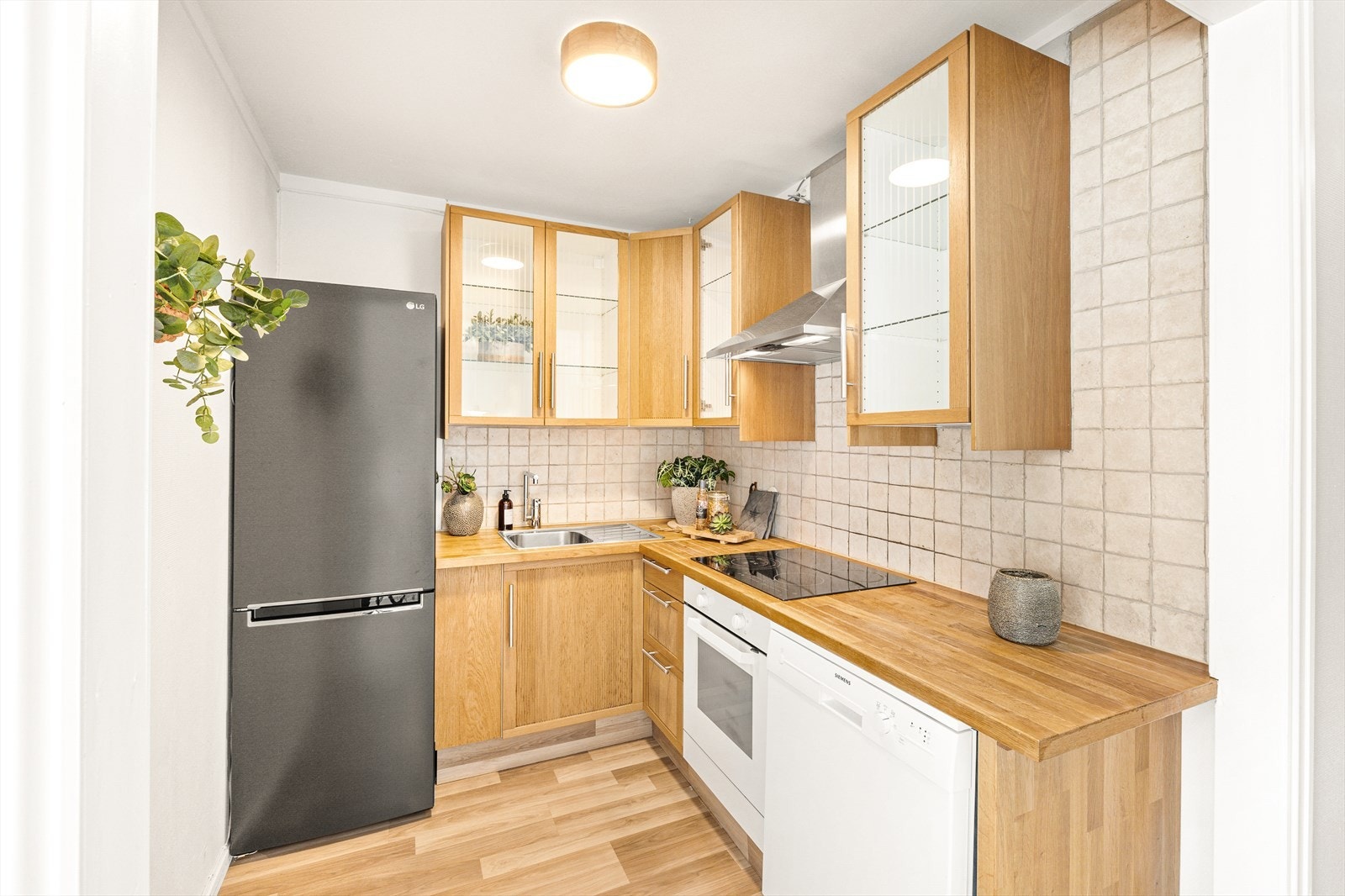 Kjøkken med laminat på gulv, malte strier på vegger og malt tak. Galleribilde