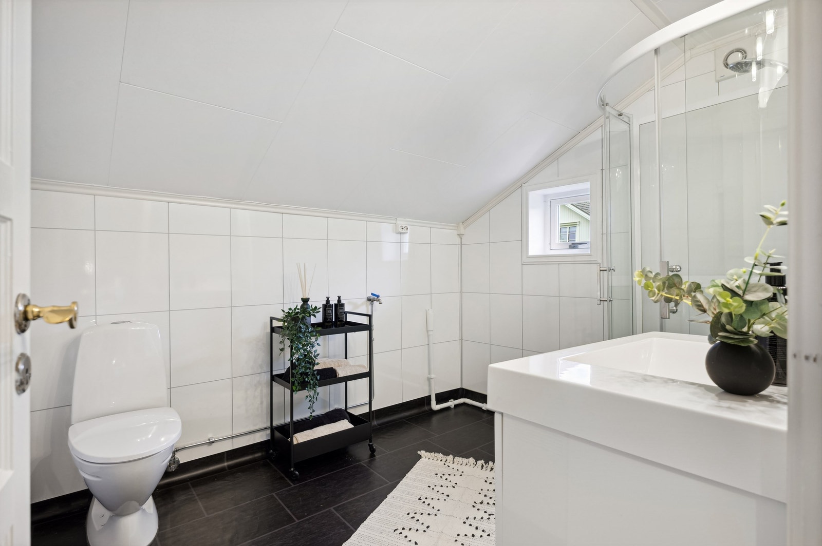 Badet har opplegg for vaskemaskin og frittstående toalett Galleribilde