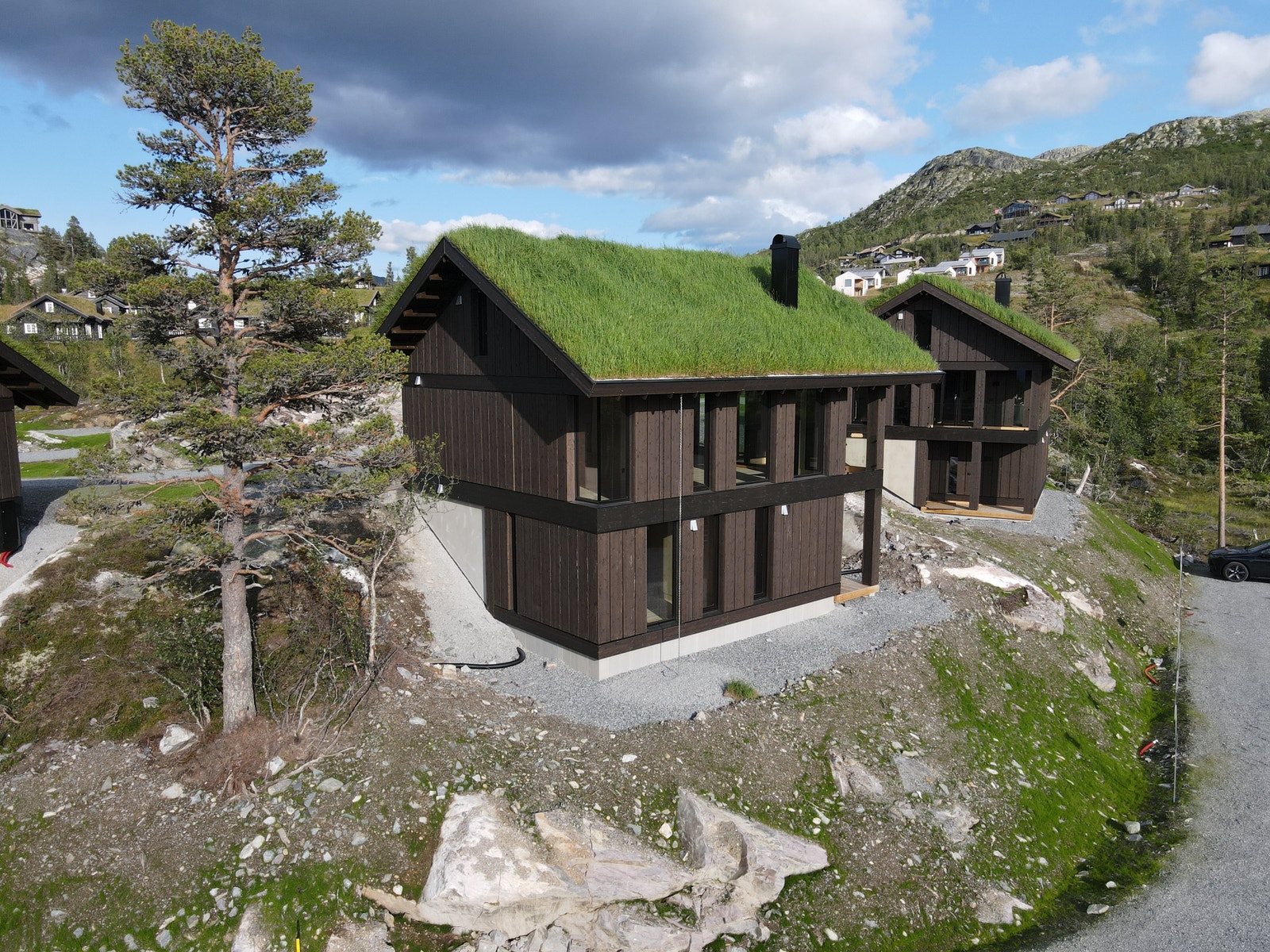 En spesialtilpasset hyttemodell for skrått terreng. Hytta inneholder sokkeletasje, hovedetasje og hems. Galleribilde