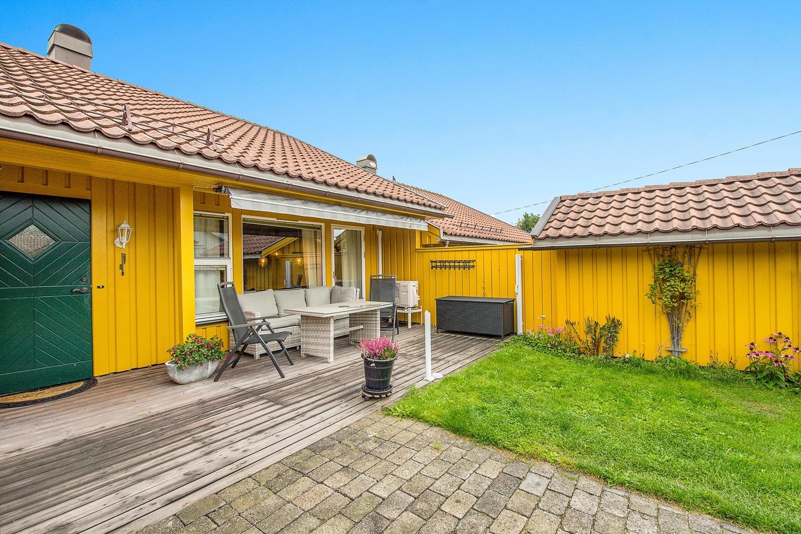 Boligen har en hyggelig uteplass, hvor det er plass til bilen ved inngangspartiet Galleribilde