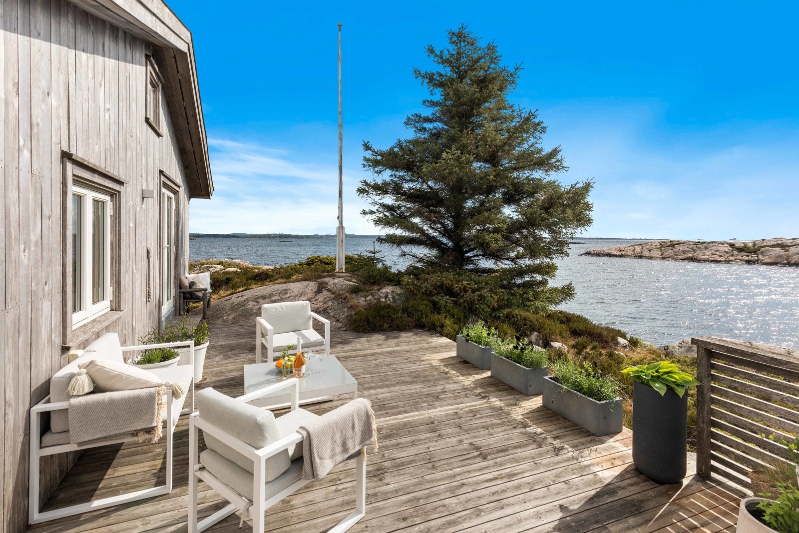 Det er opparbeidet terrasseareal på tre av hytteveggene - her fra terrasse mot øst med utsikt til Oksøy fyr og havet. Galleribilde