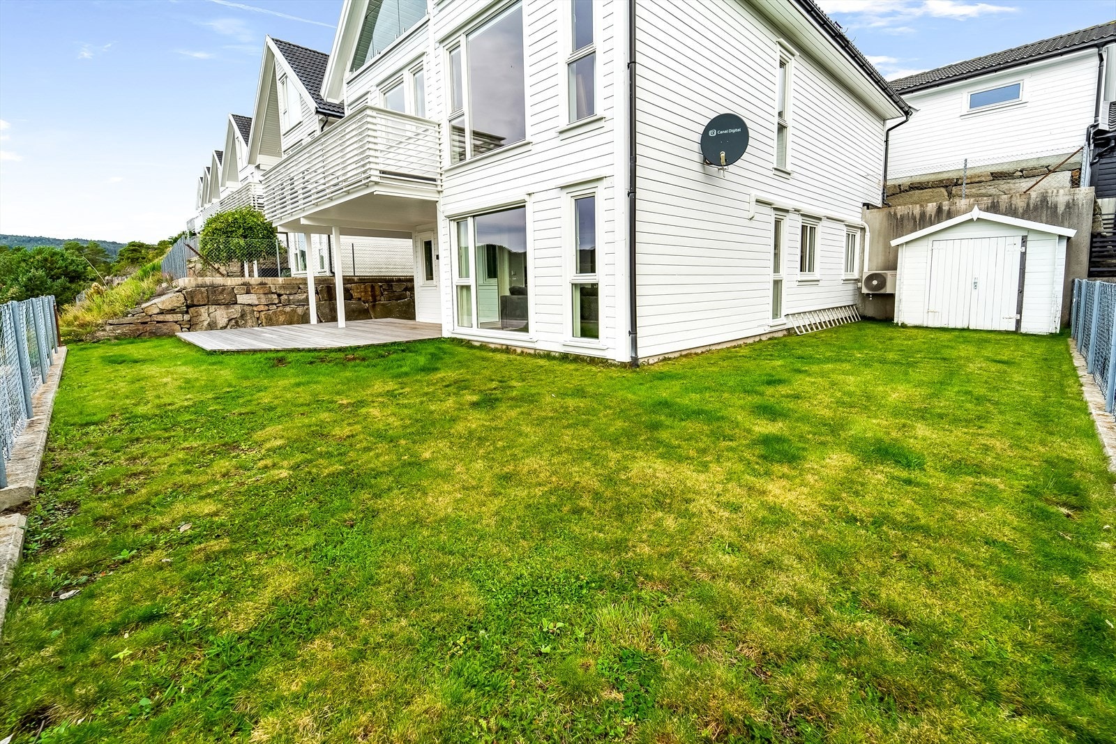 Pent opparbeidet uteområde med plen og terrasse. Galleribilde