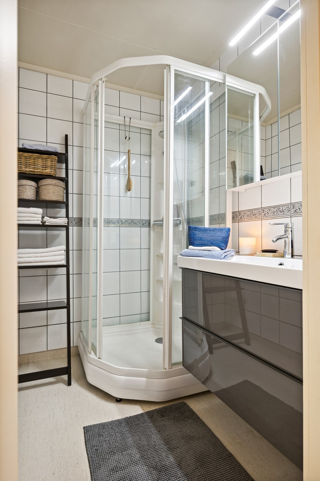 Badet er innredet med baderomsinnredning med servant og dusjkabinett. Galleribilde