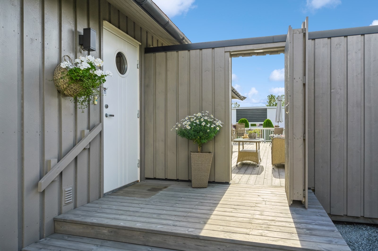 Inngangspartiet er pent oppbygget med trapp og terrasseplatting, samt tilgang til terrassen via dør i skillevegg. Galleribilde