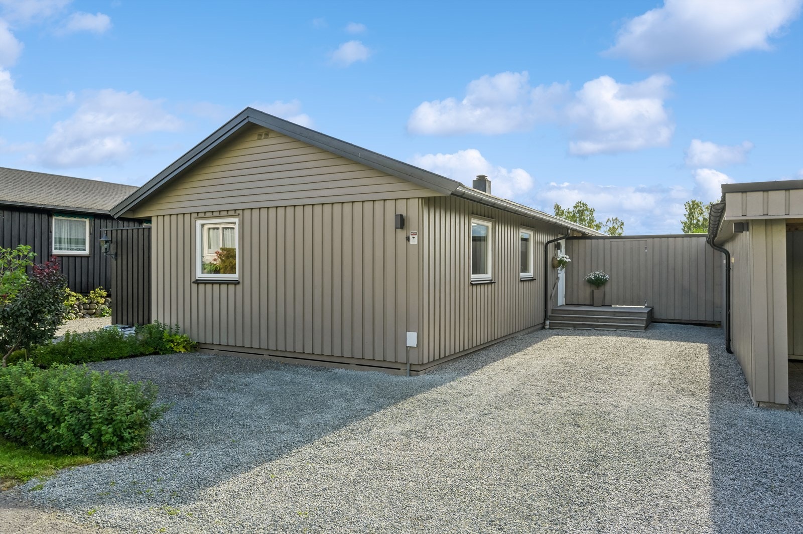 Eiendommen gir et godt førsteinntrykk med gruset gårdsplass og tilgang til carport med 1 biloppstillingsplass, samt til to utvendige boder. Galleribilde