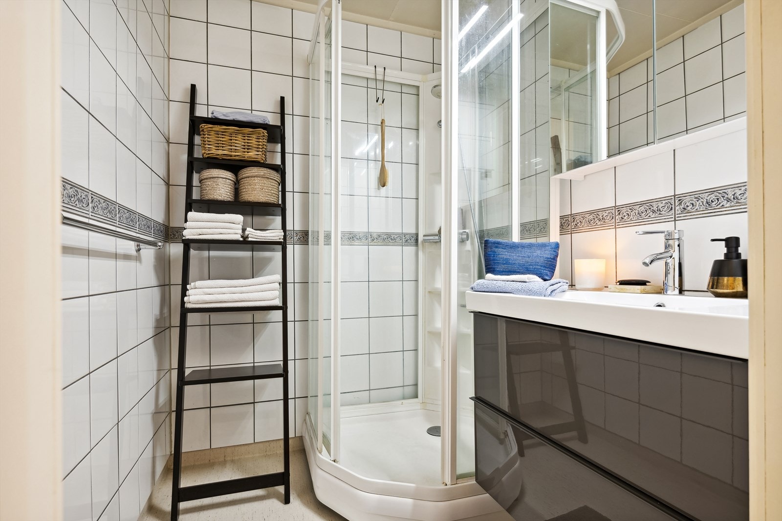 Badet er av eldre dato med fliser på veggene og belegg på gulvet, med stråleovn over dør som varmekilde. Galleribilde