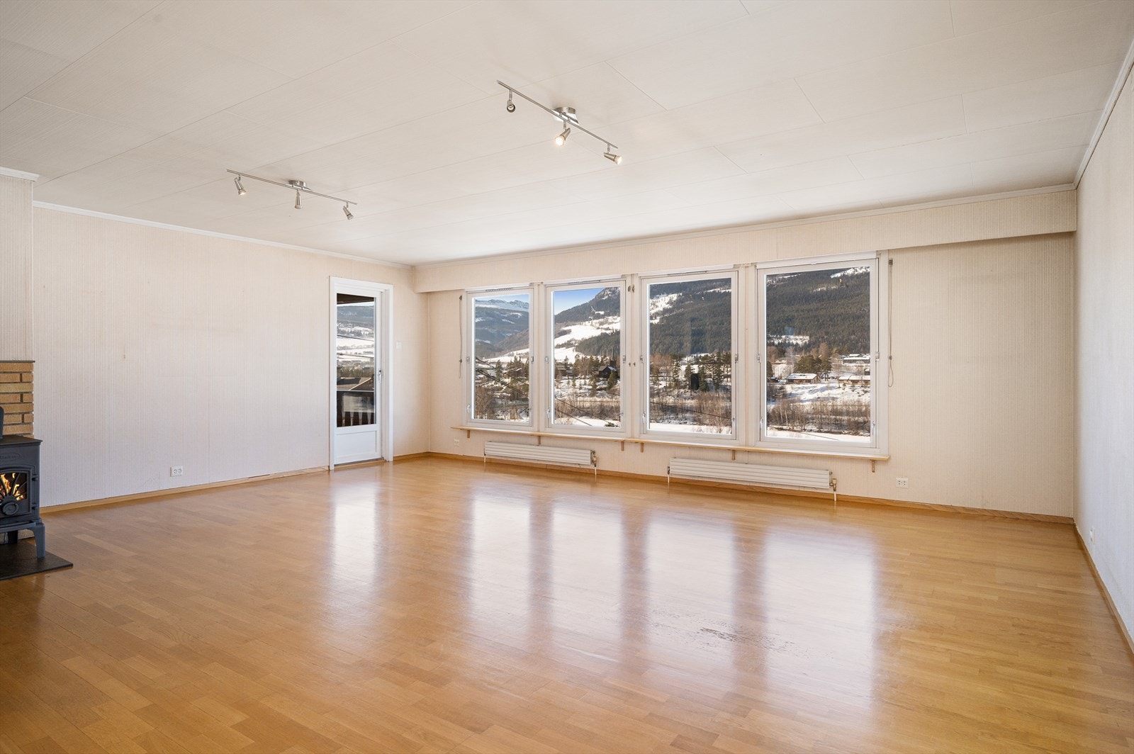 Lys og romslig stue med utgang til over bygget veranda og terrasse. Galleribilde