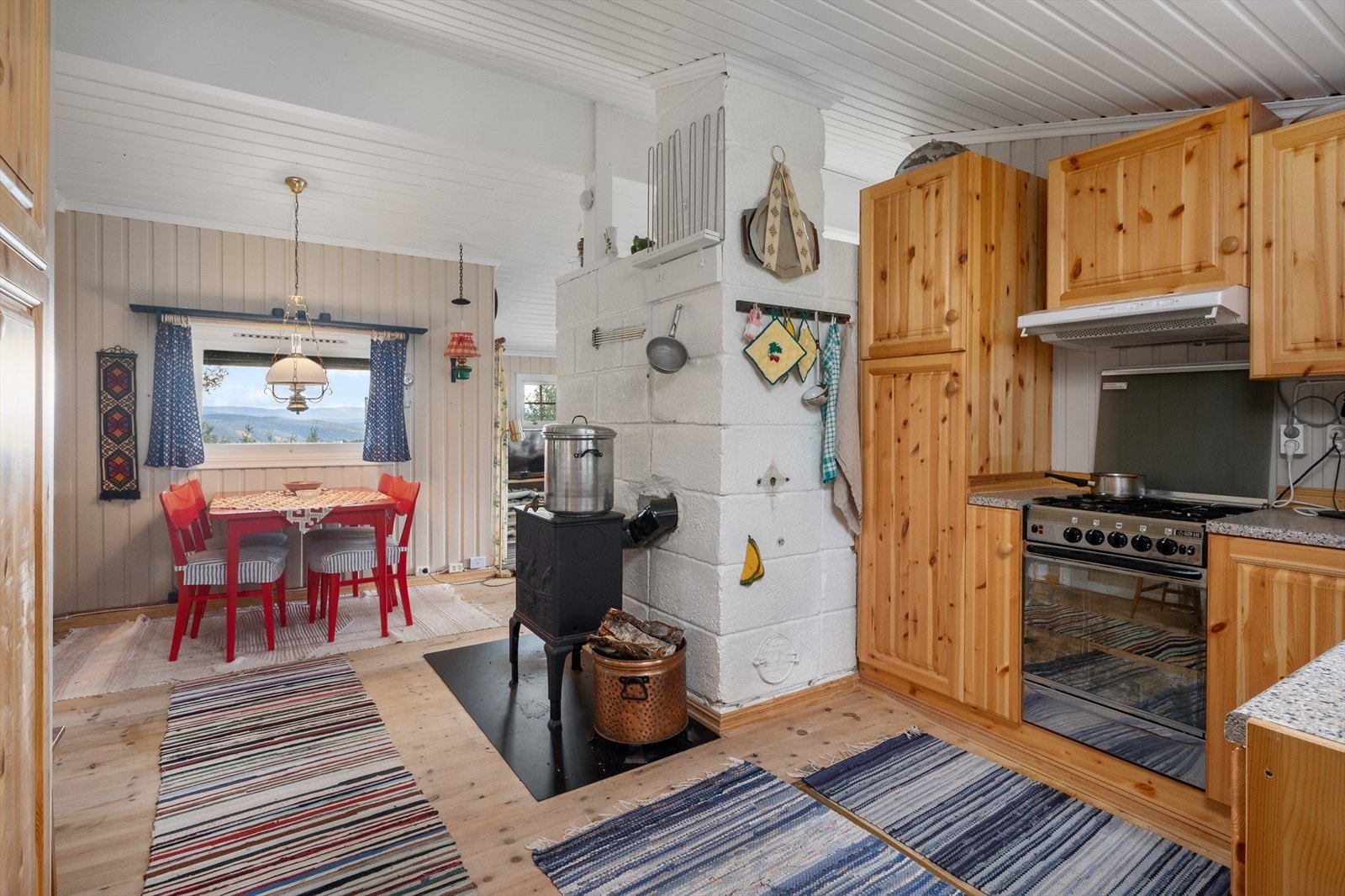 Kjøkken har vedovn som gir god varme og er fin å varme opp vann på. Spiseplass med meget fin utsikt! Galleribilde