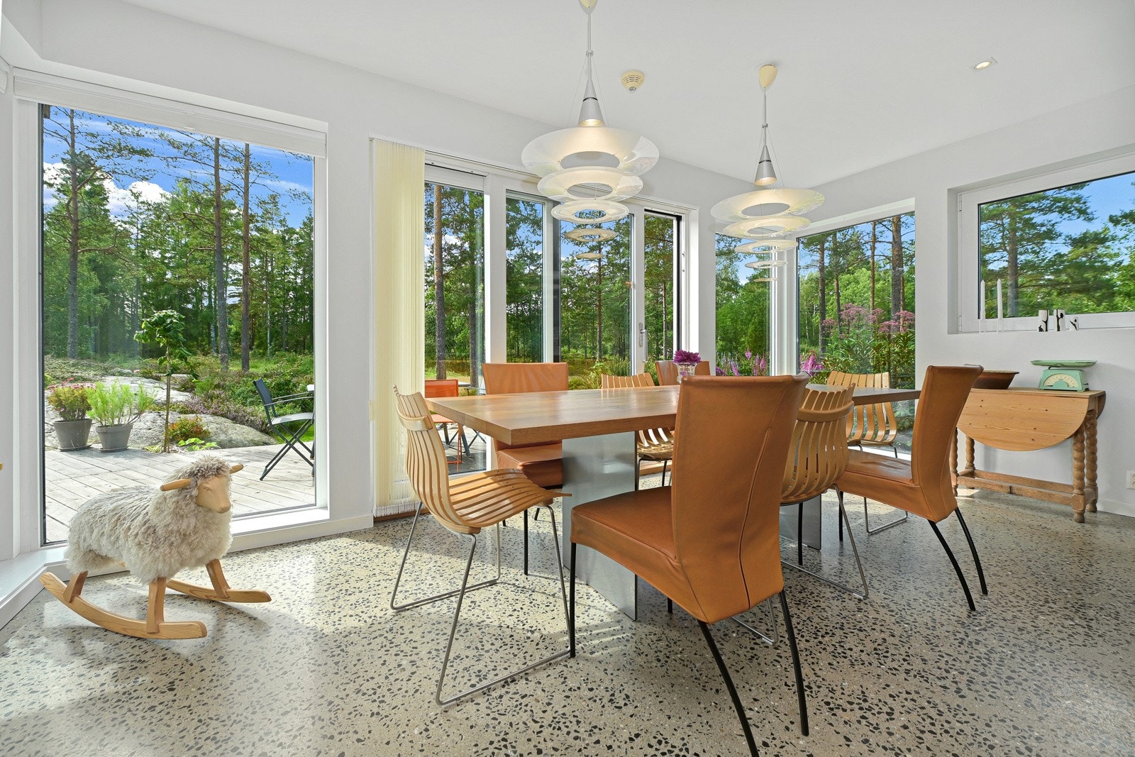 Ved flotte glassfasader ytterst i rommet er det god plass til langbord og det er skyvedør ut til terrassen, slik at det er lett å ta med måltidene ut. Galleribilde