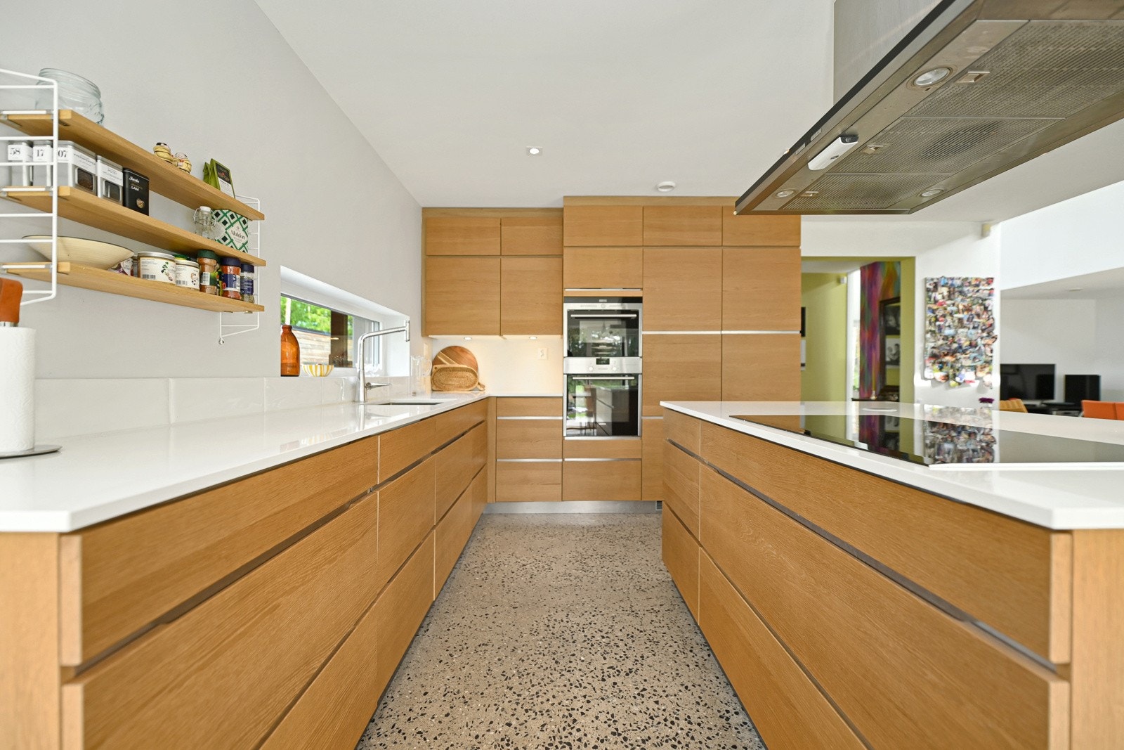 Over benken er det en rad med hvite, glansfulle metrofliser og det er belysning under overskapene Galleribilde