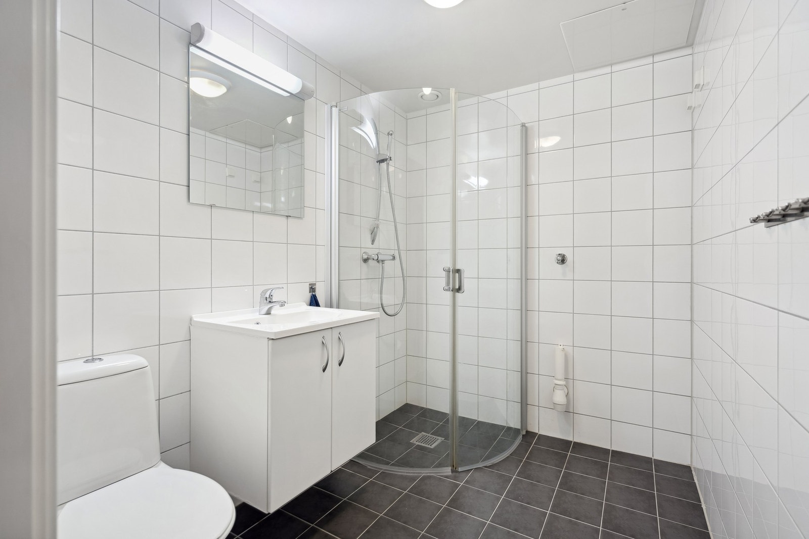 Videre har boligen et lyst og flislagt baderom hvor det også er opplegg for vaskemaskin. Galleribilde