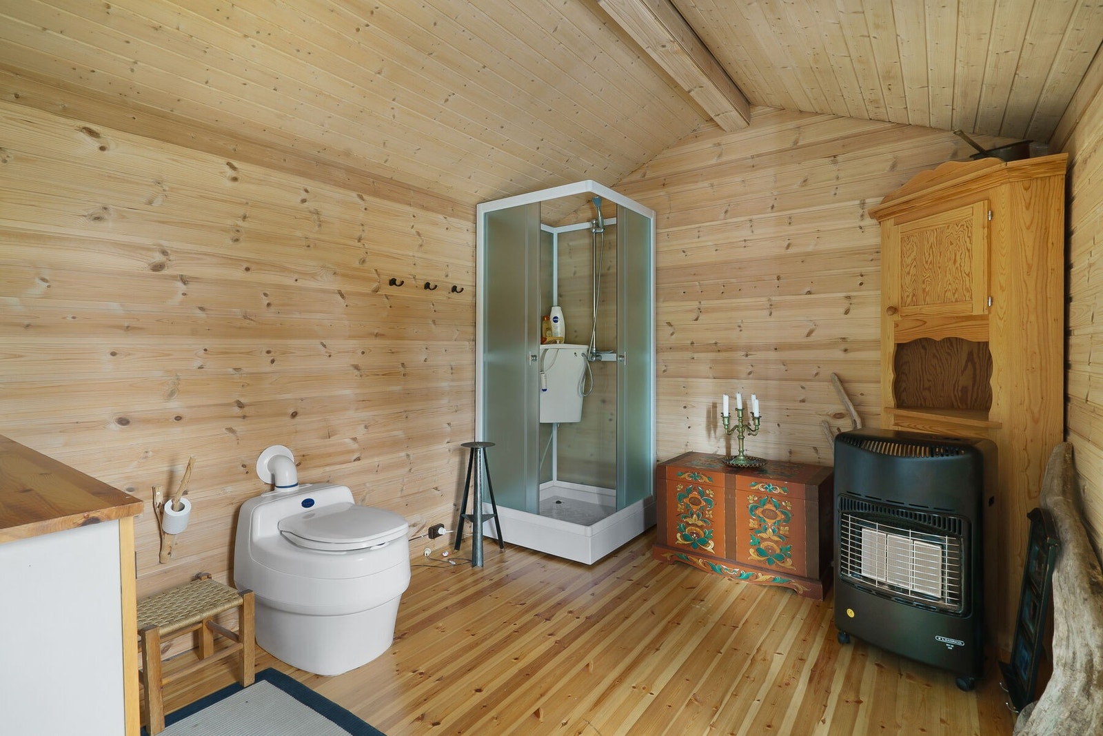 På badet er det 12 V dusj. Innredning med vask (gråvannet går rett ut. Det er pumpe på armaturet men denne er defekt. Separett toalett med poser. Galleribilde