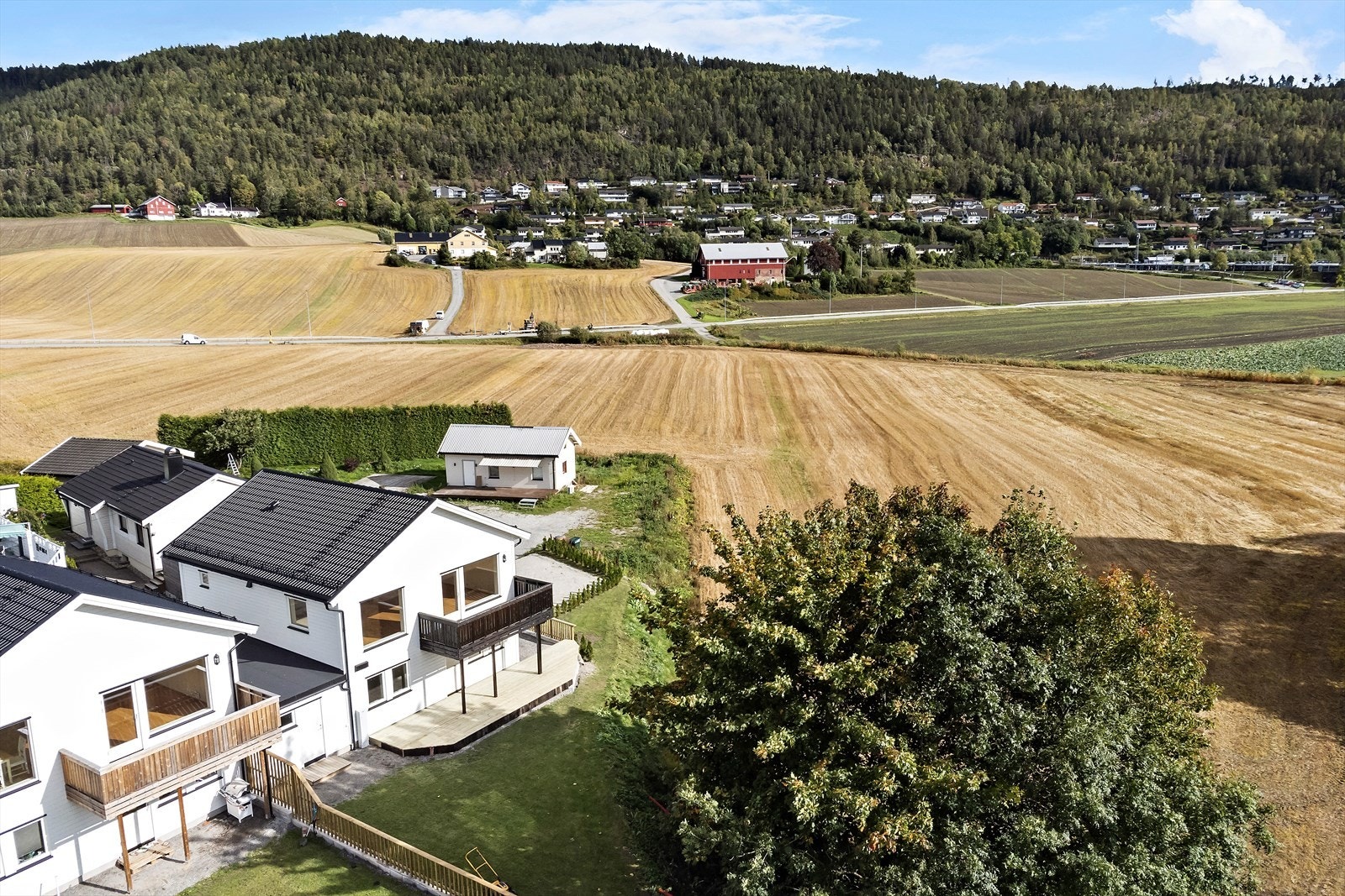 Stor tomt med god plass til lek og spill. Deling av uteareal i rett linje mellom boligen adskilt med gjerde og skjermvegg Galleribilde