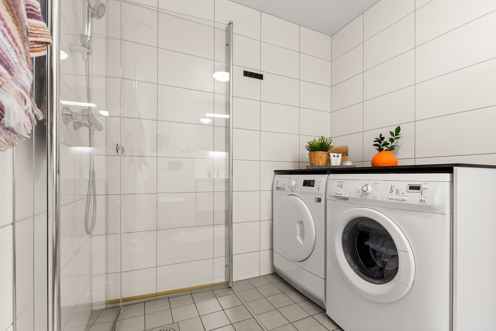 Leiligheten andre baderom er romslig og lyst, med varmekabler, dusjhjørne, vegghengt toalett, stort servantskap, opplegg for vaskemaskin og tørketrommel. Galleribilde