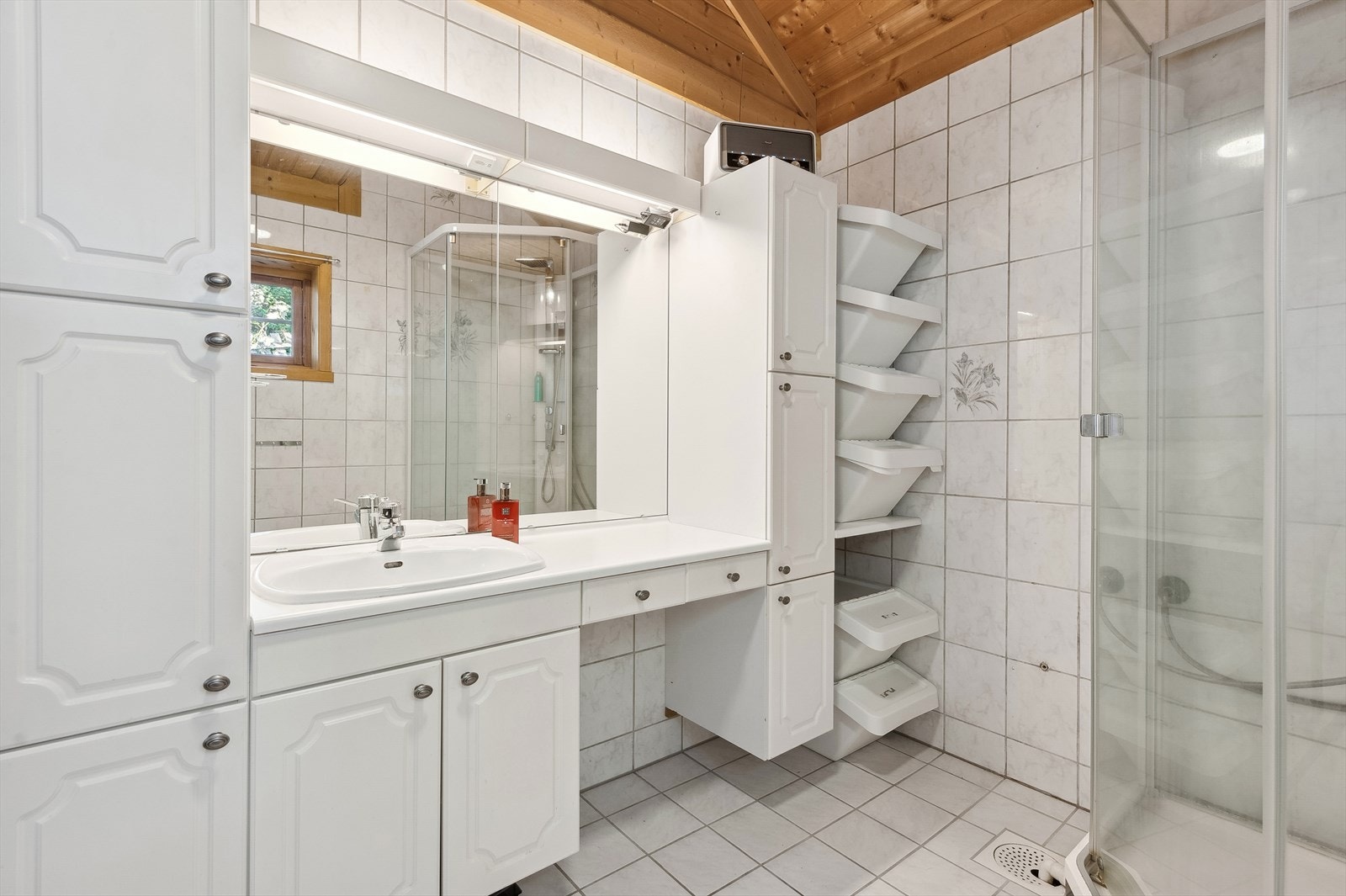 Boligen har to bad, ett i hver etasje. Hovedbadet i 1. etasje er flislagt med varmekabler i gulv.
Rommet er innredet med servantskap med laminert benkeplate og tilhørende høyskap med god plass til baderomsartikler. Galleribilde