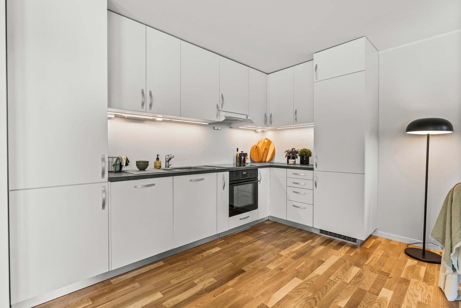Kjøkkenet er utstyrt med "topp-line" hvitevarer fra IKEA og har laminert mørk grå benkeplate. Galleribilde