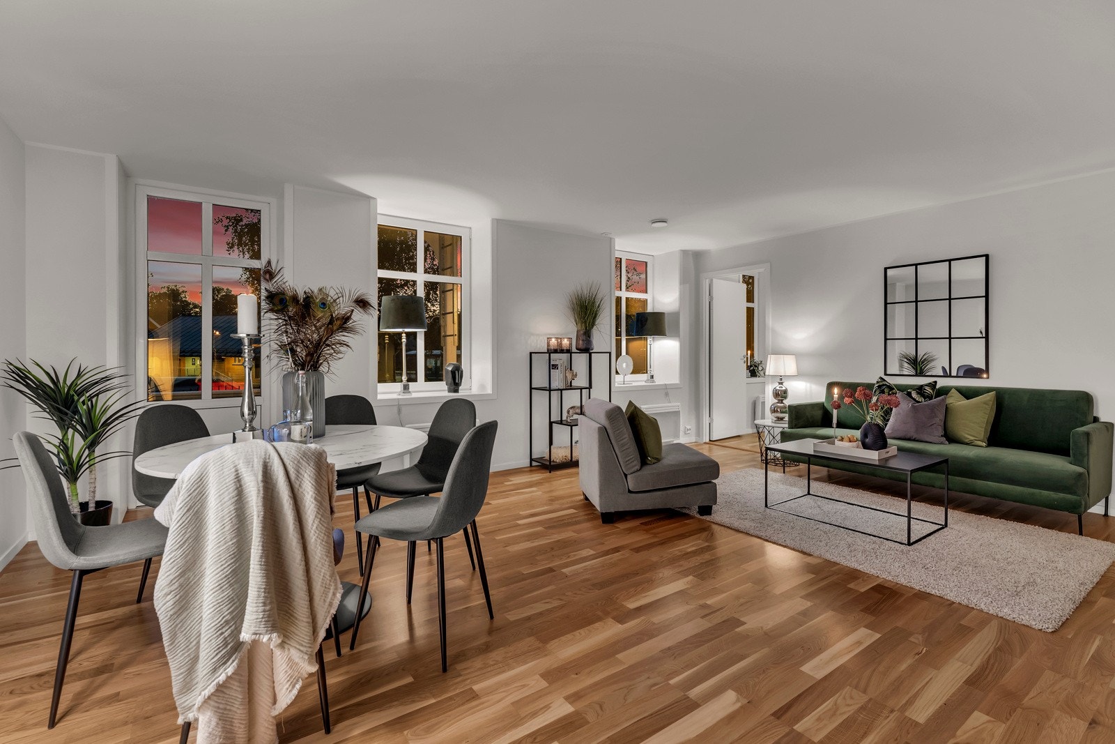 Det er luftig takhøyde og god plass til et spisebord mellom stuen og kjøkkenet. Rikelig med skap og benkeplass og med lett tilgang til balkongen fra store vindusflater. Galleribilde