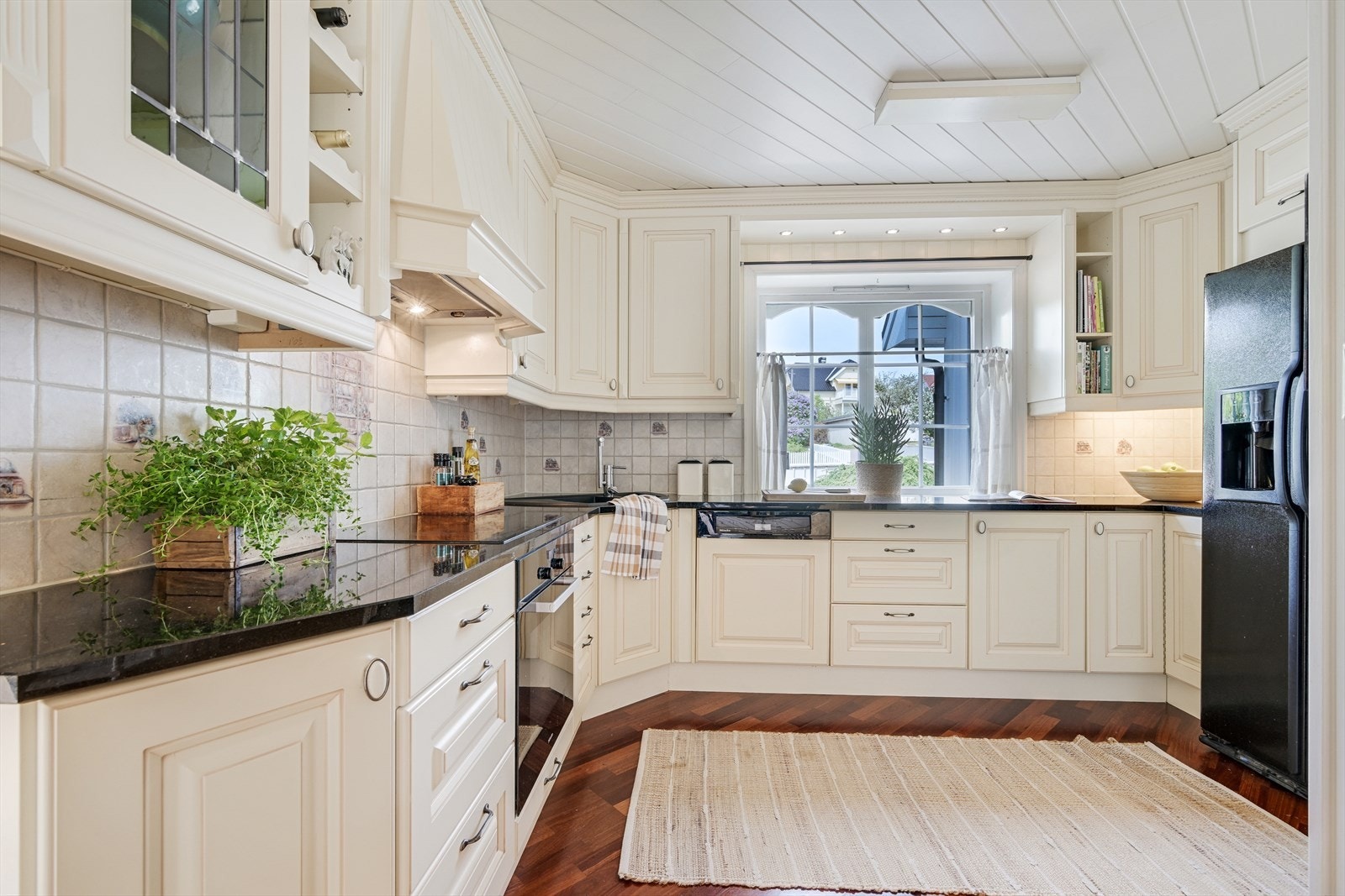 Romslig åpent kjøkken med takhøye overskap og godt med lagring i skuffer og skap. Galleribilde