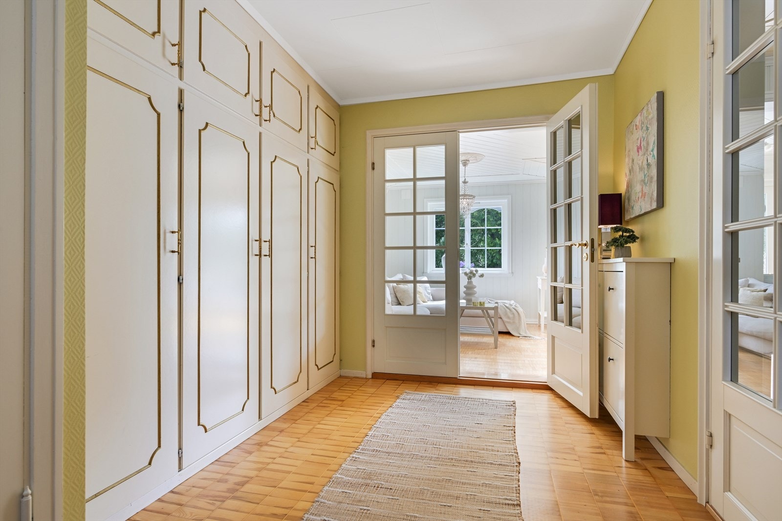 Entré med garderobe, med doble glassdører til stue og spisestue. Galleribilde